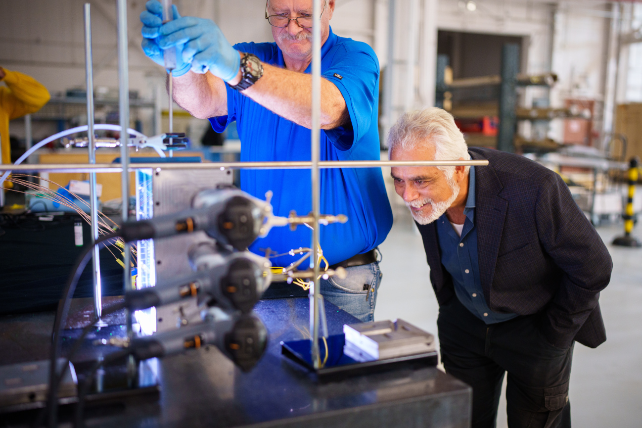 Sal Rodriguez, right, looks on in amazement as technologist Robin Sharpe injects dye into the dimpled model they built, showing the way dimples increase heat transfer in water.