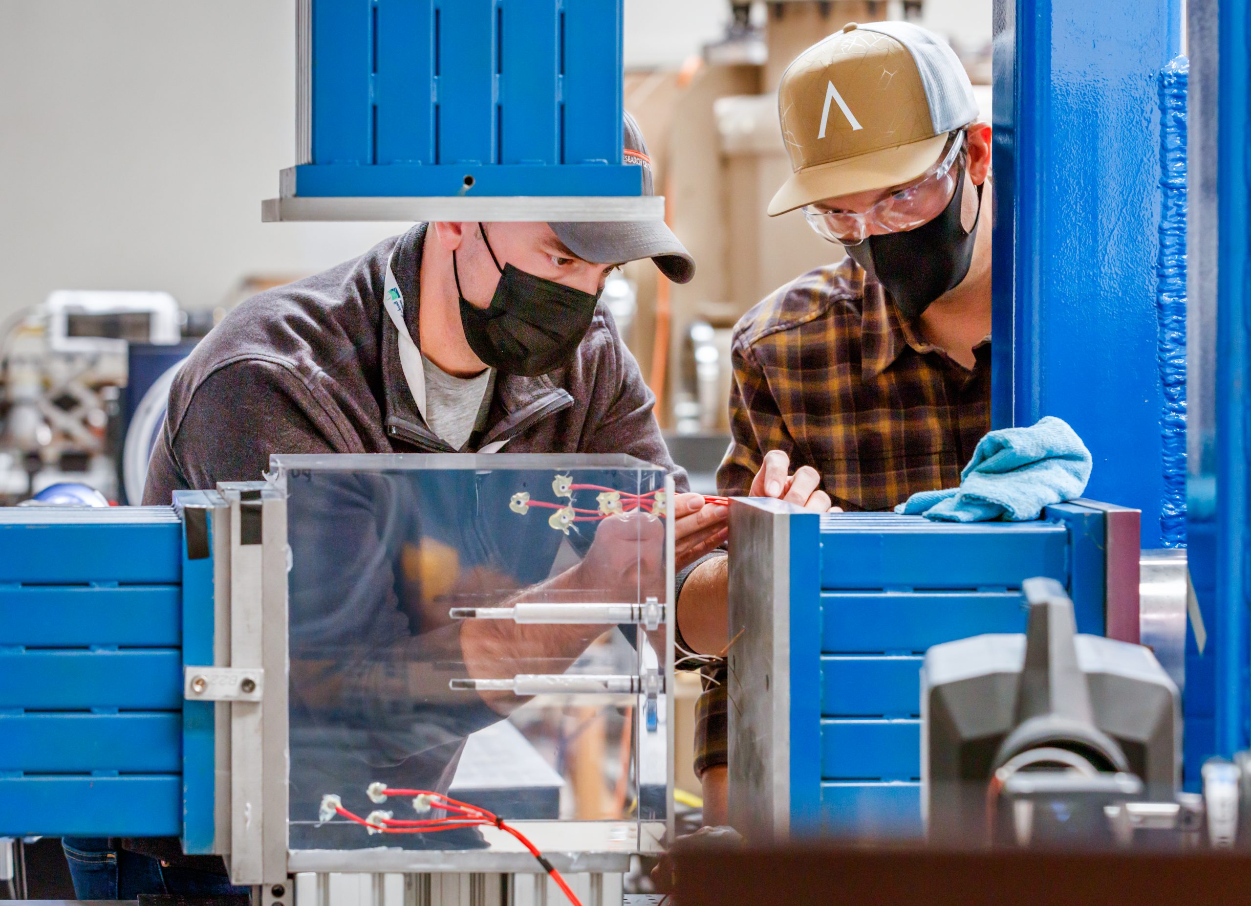 Eric Robey, left, a Sandia National Laboratories mechanical engineer, and Joseph Pope, a Sandia technologist, prepare a plexiglass cube for a small-scale explosion. The information from this study could be used to create new geothermal energy systems in locations where it is currently not feasible.