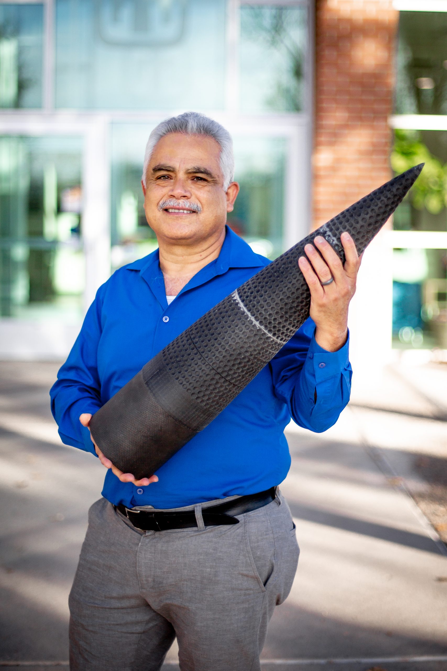Sal Rodriguez showing the dimpled rocket he helped create as part of a 2022 fluid dynamics project with UNM.