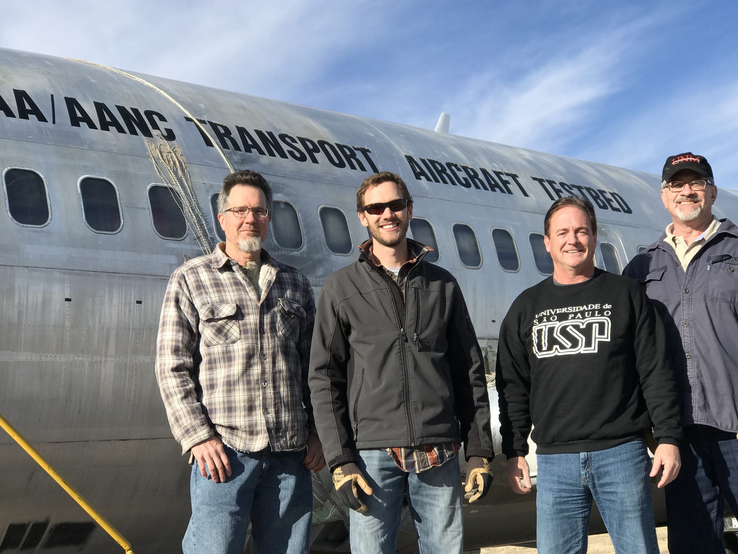 Sandia National Laboratories' members of the Airworthiness Assurance Center team, from left to right, Clay Newton, Stephen Neidigk, Dennis Roach and Tom Rice, with the 737 aircraft test bed. The 737-200 aircraft, more than 50 years old, served as a full-scale test bed after its career as a passenger plane. The test bed helped develop numerous inspection programs at the center hangar facility Sandia operated at the Albuquerque International Sunport.