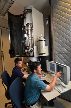 Principal investigators Paul Kotula, left, and Ping Lu of Sandia National Laboratories show off the Labs’ new aberration-corrected scanning transmission microscope, which has a unique combination of X-ray detectors and very high resolution and is capable of doing analyses in far less time than its predecessor.