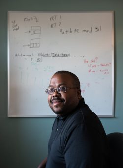Sandia National Laboratories cybersecurity expert Chris Jenkins sits in front of a whiteboard with the original sketch of the moving target defense idea for which he is the team lead. When the COVID-19 pandemic hit, Jenkins began working from home, and his office whiteboard remained virtually undisturbed for more than two years.