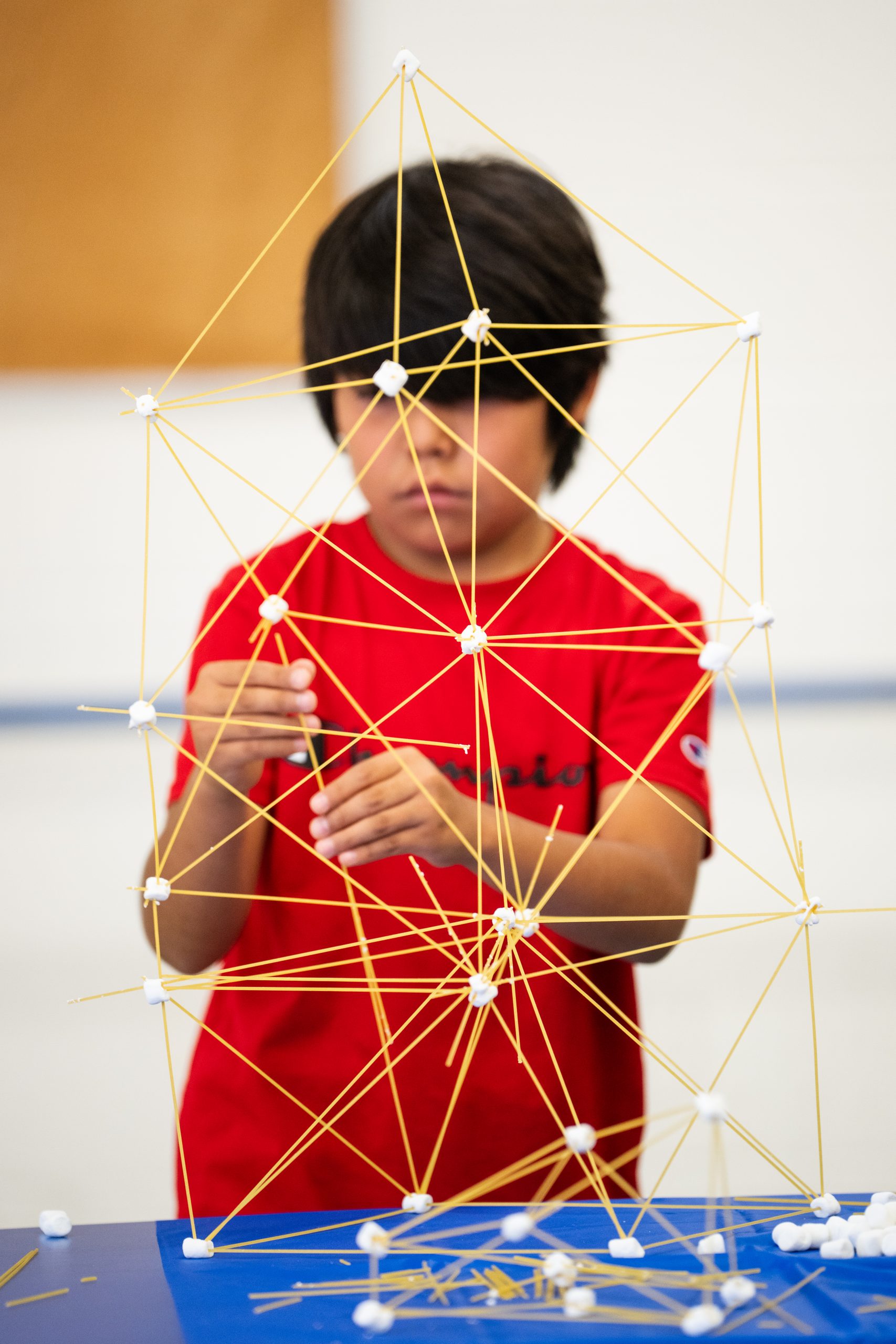 Matthias White, 9, accomplishes his goal of building a marshmallow and spaghetti tower taller than himself during Sandia National Laboratories' STEM in the Sun event.