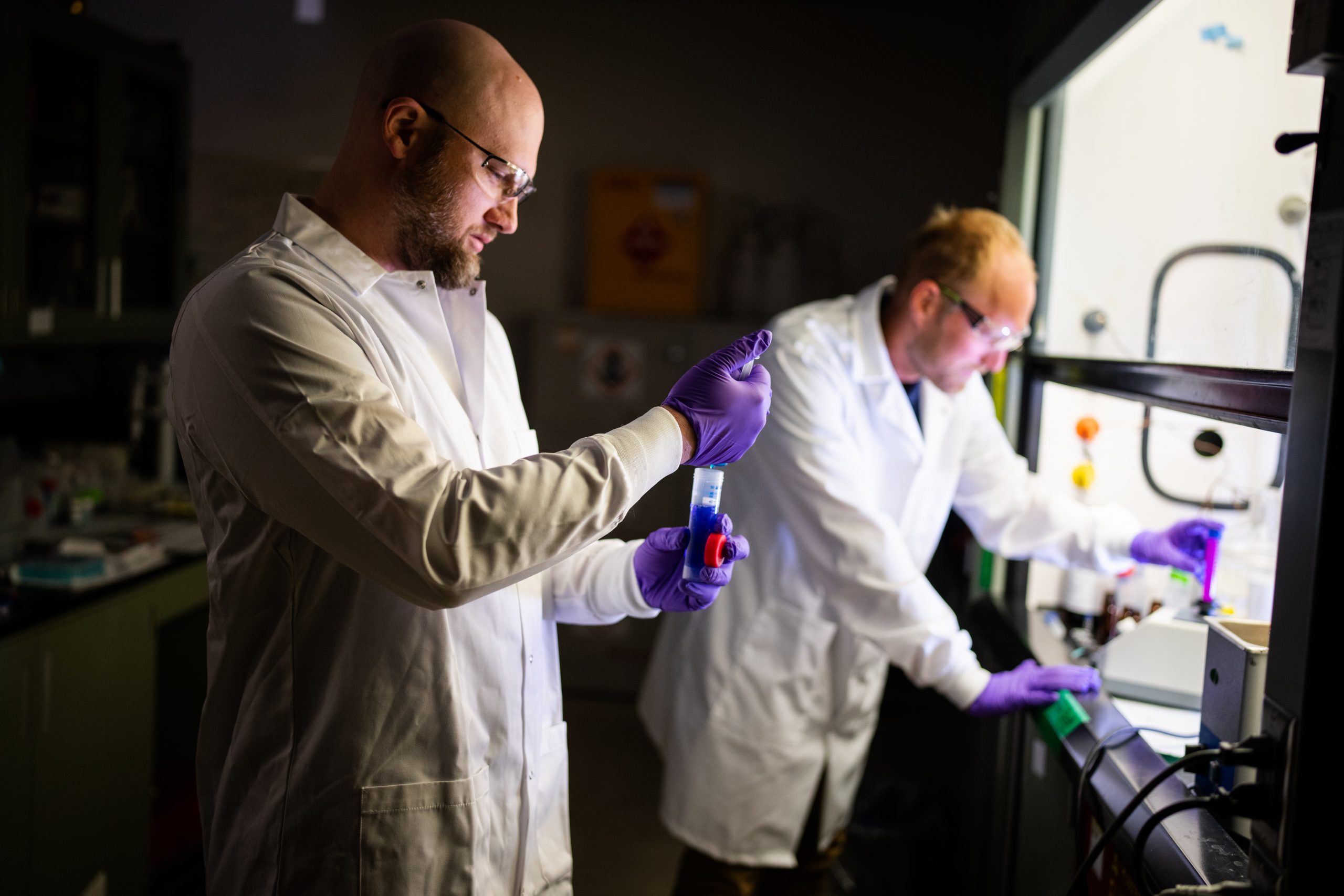 Ryan Davis, left, and Andrew Knight working at Sandia National Laboratories on a new material to better absorb PFAS on a large and small scale.