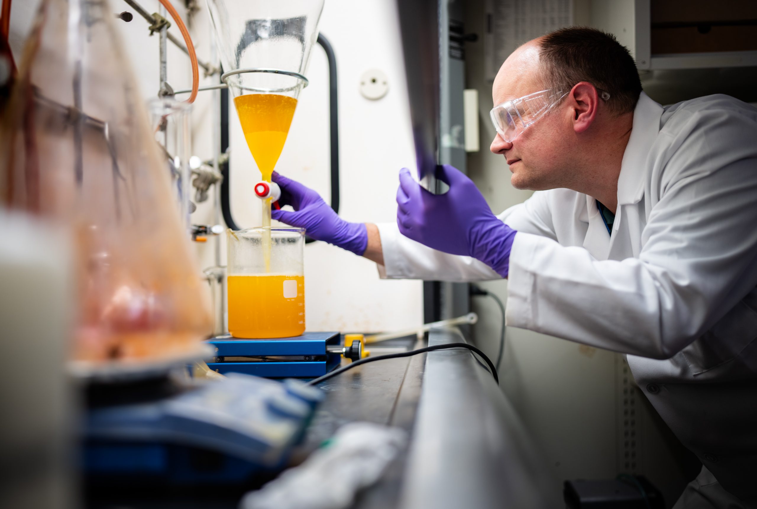 Sandia National Laboratories chemist Chad Staiger uses a separatory funnel to remove byproduct from the synthesis of a molecule.