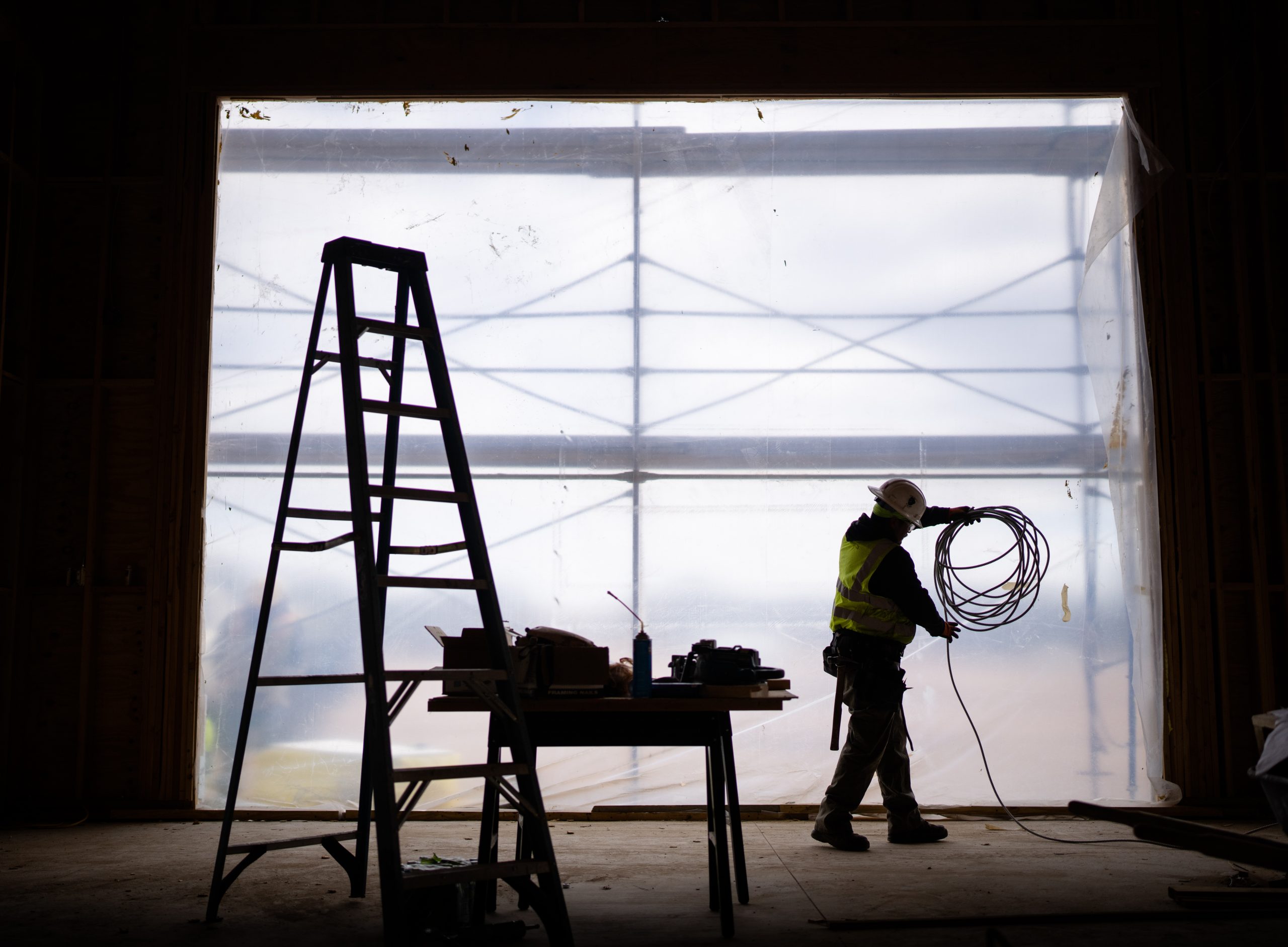 Pluma electrician Guadalupe Cardoza coils wire while working on a maintenance garage in Eldorado, N.M.