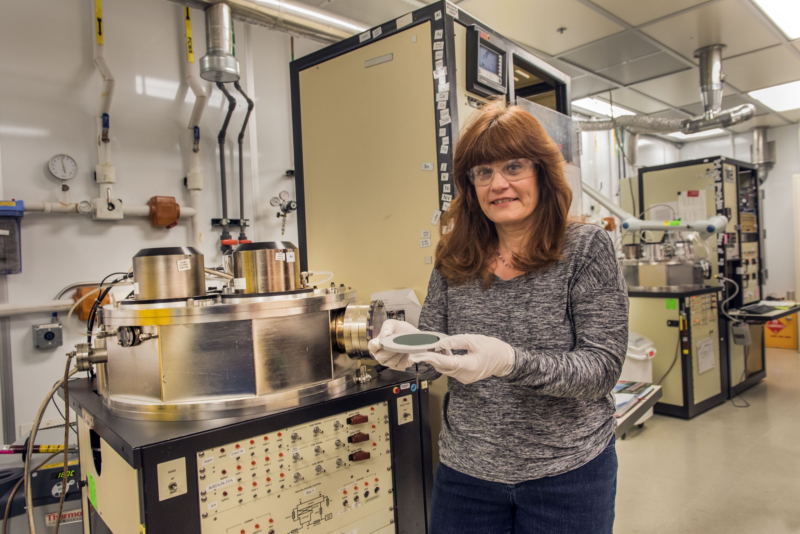 Sandia National Laboratories technologist Catherine Sobczak prepares a silicon wafer to load into a machine. She has been honored with the inaugural Thin Film Distinguished Technologist Award from the American Vacuum Society.