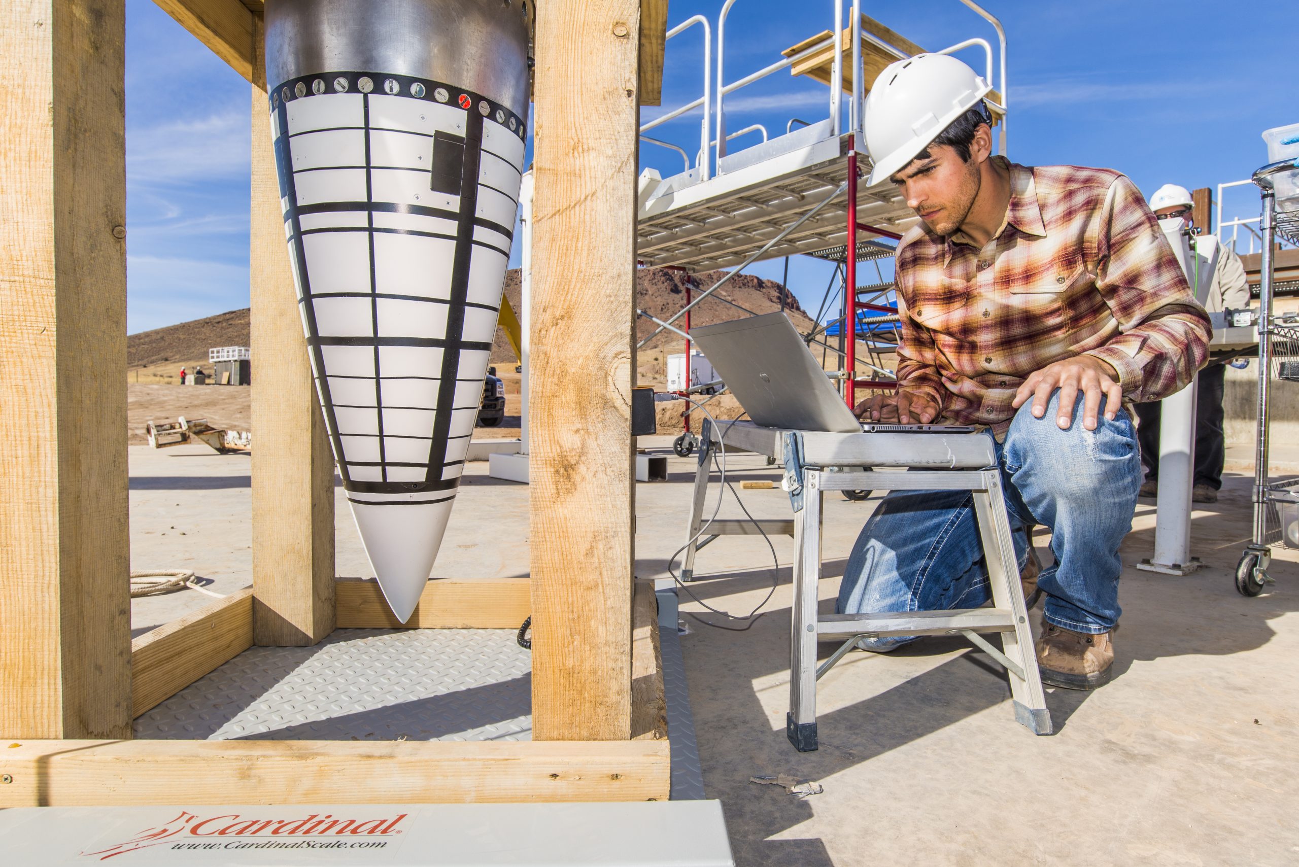 Tyler Keil, lead engineer for a test series using Sandia National Laboratories’ Davis gun, performs a final diagnostics check on a data recorder for an impact test on the nose assembly of a mock B61-12. Data gathered from the test is helping analysts calibrate computer models.