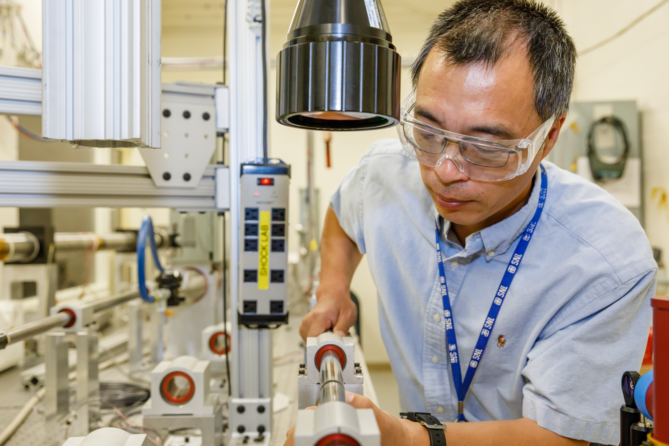 Bo Song, who developed the Experimental Impact Mechanics Lab at Sandia National Laboratories, places material for shock testing in the center of a Kolsky bar. When a gas gun is fired, the bar closes at the speed of a bullet train to assess how the material responds to stress and strain.