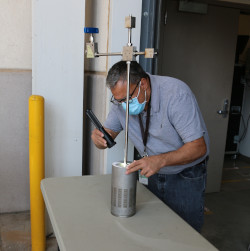 Victor Figueroa, a Sandia National Laboratories quality-assurance coordinator, inspects a specially designed stainless-steel container prior to heating it to 2000 degrees Fahrenheit to ensure the safety of the container for the storage and transportation of hazardous materials.