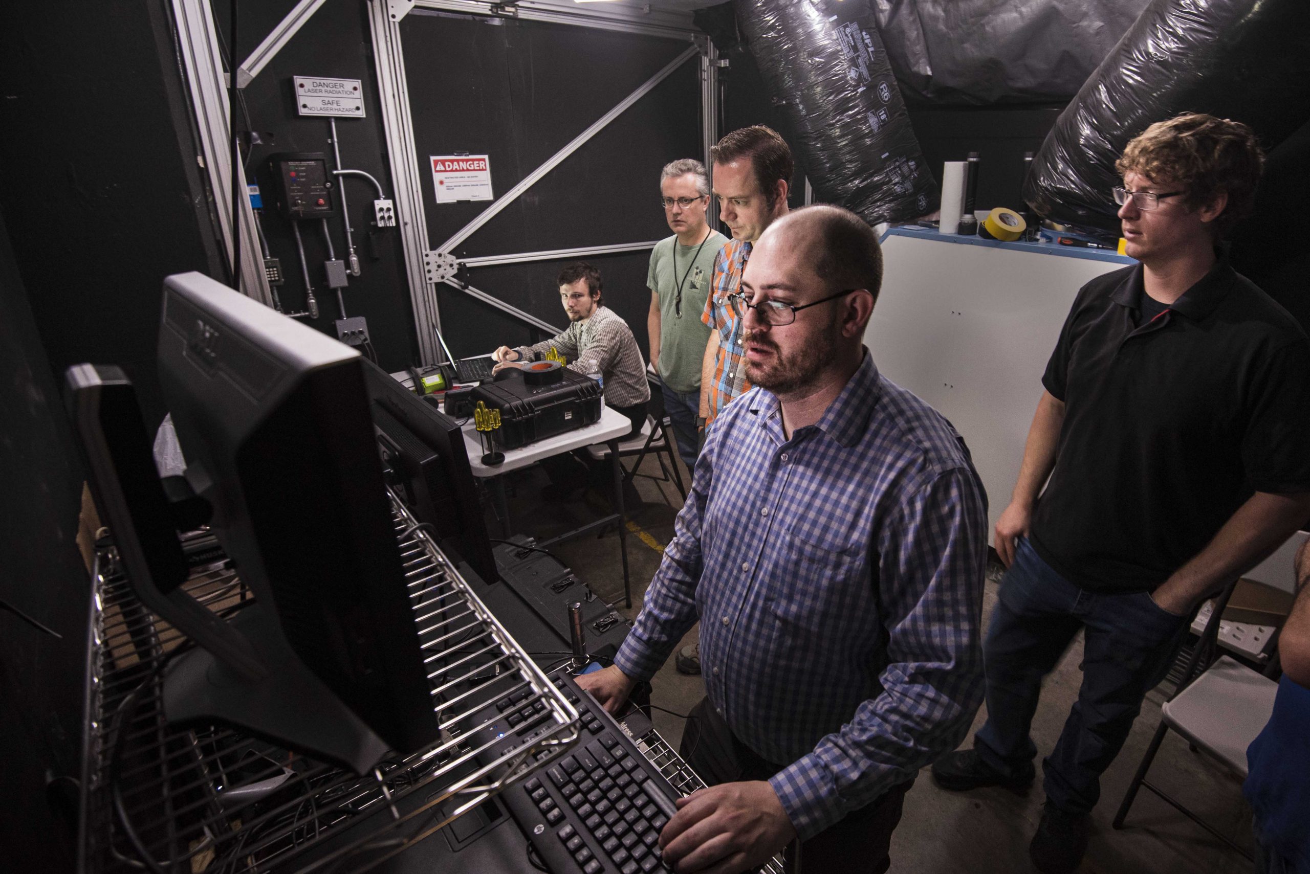 The research team reviews data coming in from a test in Sandia National Laboratories’ fog chamber. This photo was taken prior to the COVID-19 pandemic.