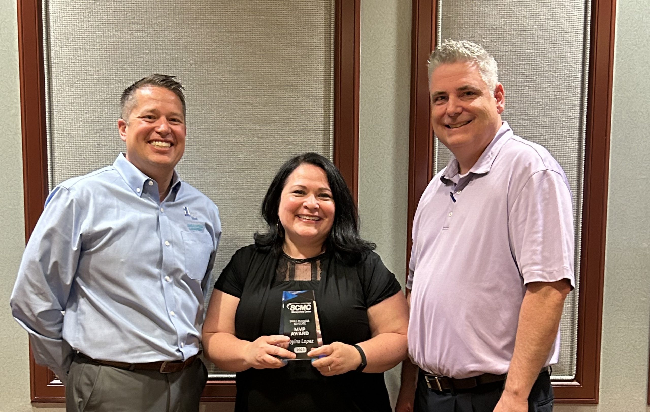 Royina Lopez, center, accepts her MVP award from the Small Business Administration’s Supply Chain Management center on May 1, 2024. Also pictured, Louis Griego, director of Sandia’s Integrated Supply Chain, left, and Scott Bissen, SCMC senior director.