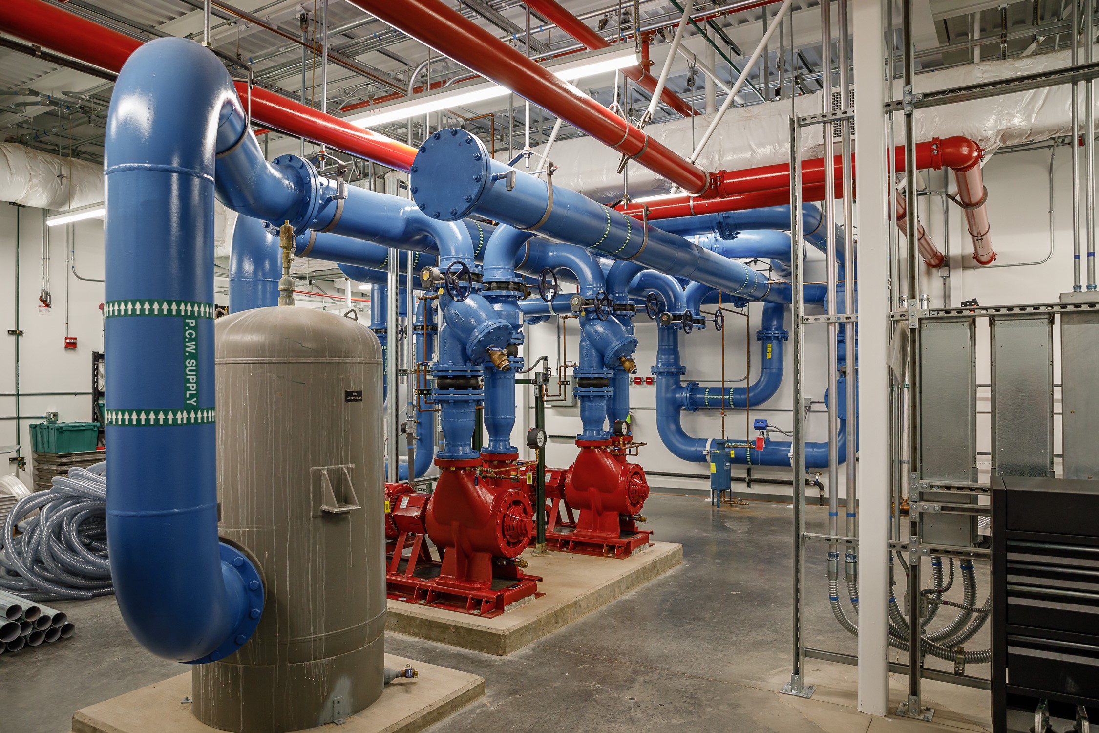 Water runs through large, uninsulated pipes, part of the processing system that provides cooling direction into the computers via the cooling distribution unit at Sandia National Laboratories.
