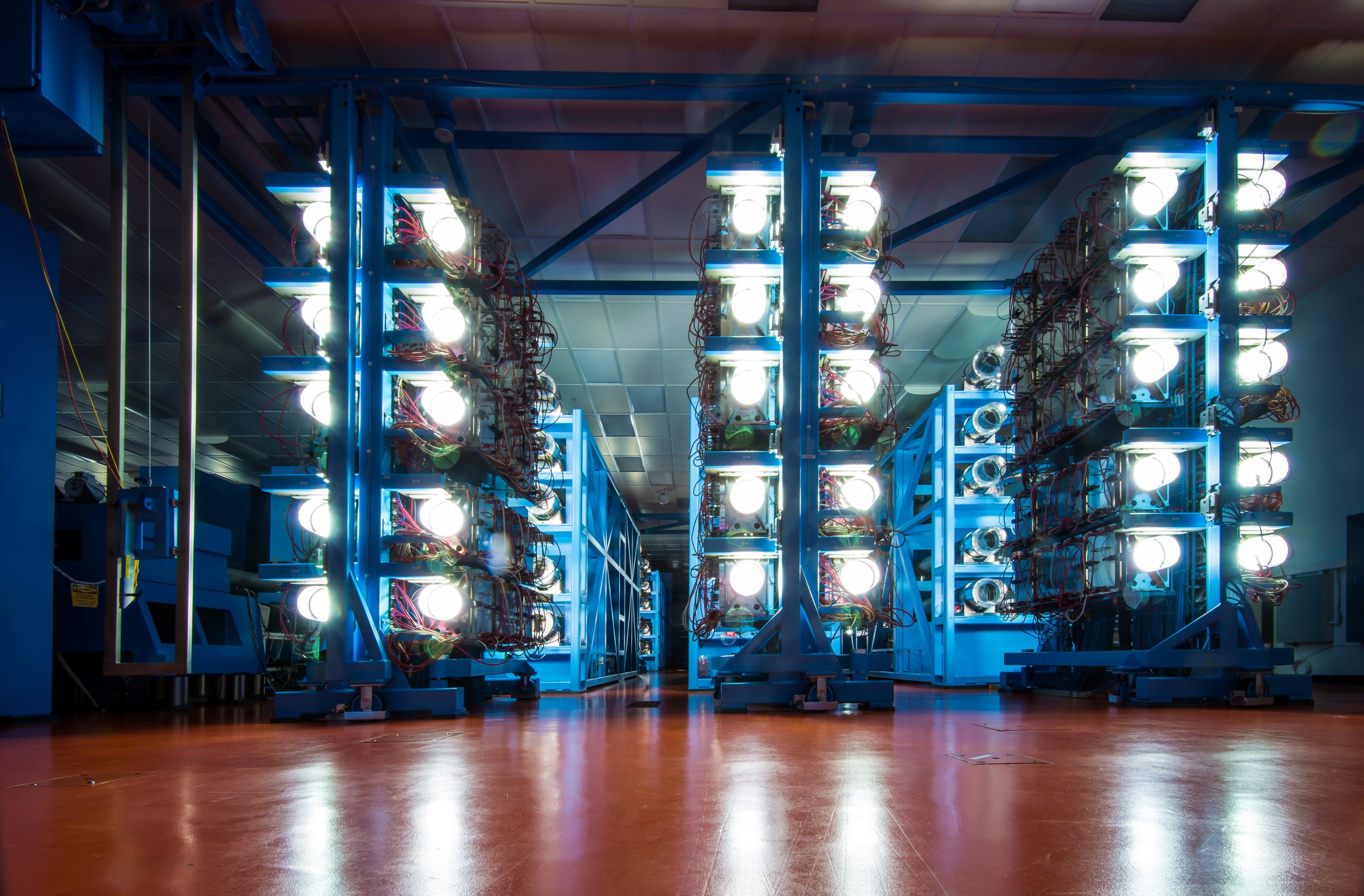 Twenty-centimeter disk amplifiers used to energize 60 laser beams glow brightly at the 100-meter-long OMEGA laser at the University of Rochester’s Laboratory for Laser Energetics. Both lasers will experiment with more efficiently preheating fusion fuel to improve the output of Sandia’s Magnetized Liner Inertial Fusion technique.
