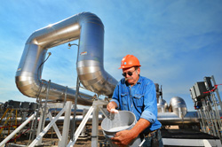 Sandia mechanical technologist John Kelton sifts through a bucket of salt beads before they are melted for use in the Molten Salt Test Loop.
