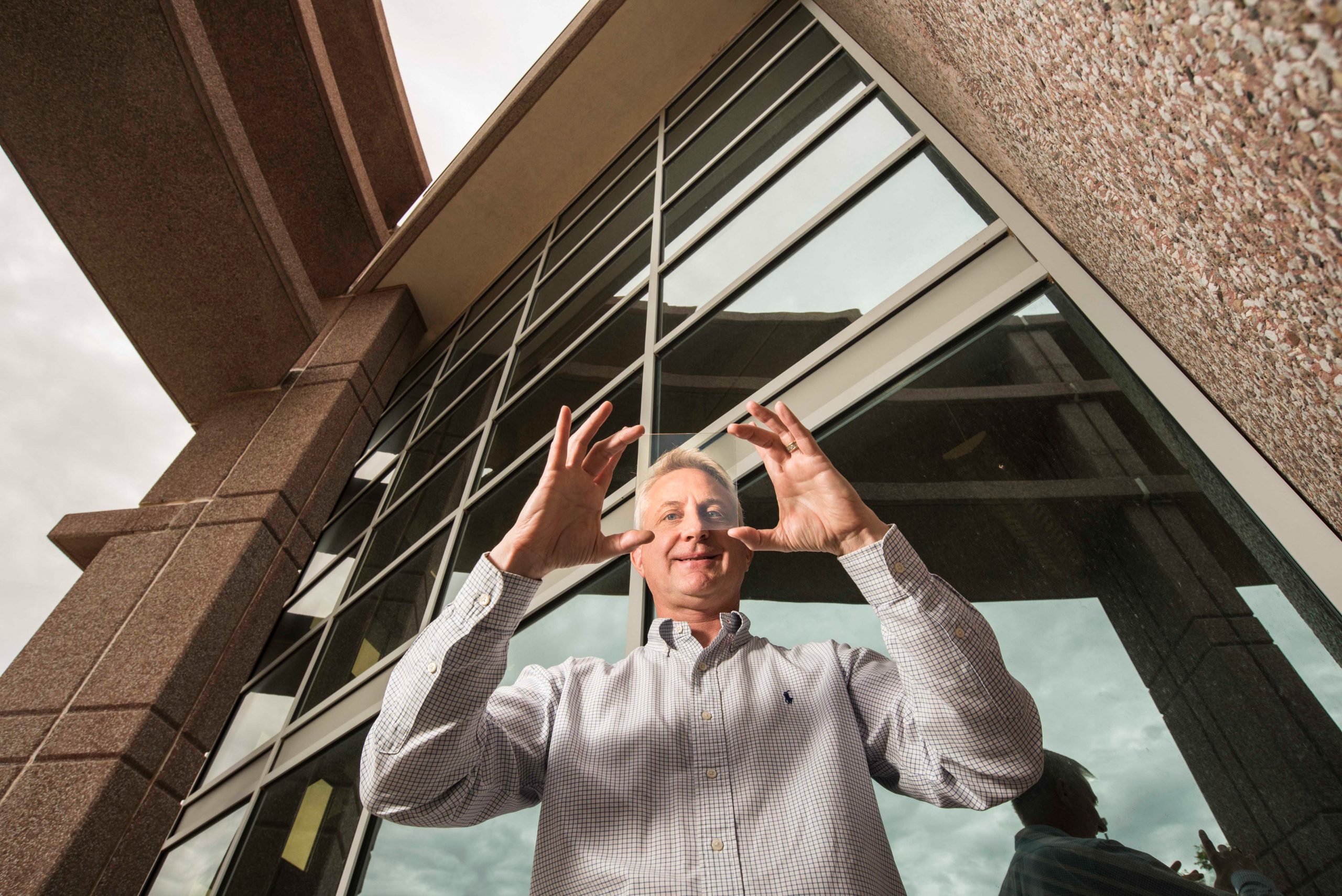 Sandia National Laboratories materials physicist Paul Clem holds a sample of nanoparticle coated glass.