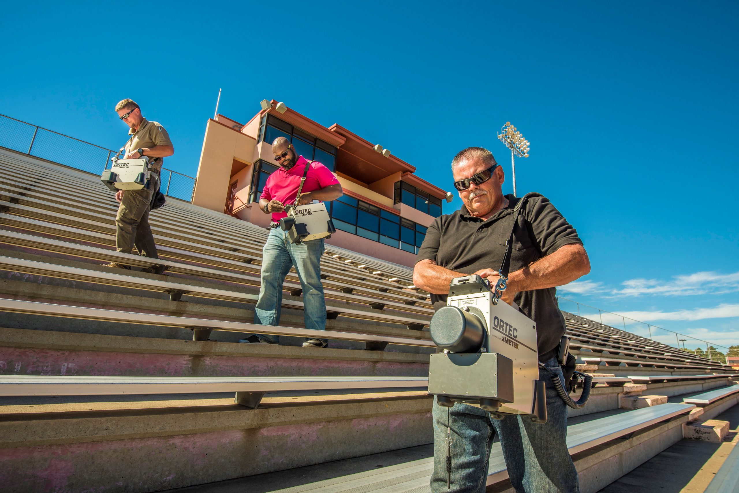 Sandia RAP members, from left to right, Kevin Rolfe, Chris Williams and Gary Baldonado scan a football stadium before a game.