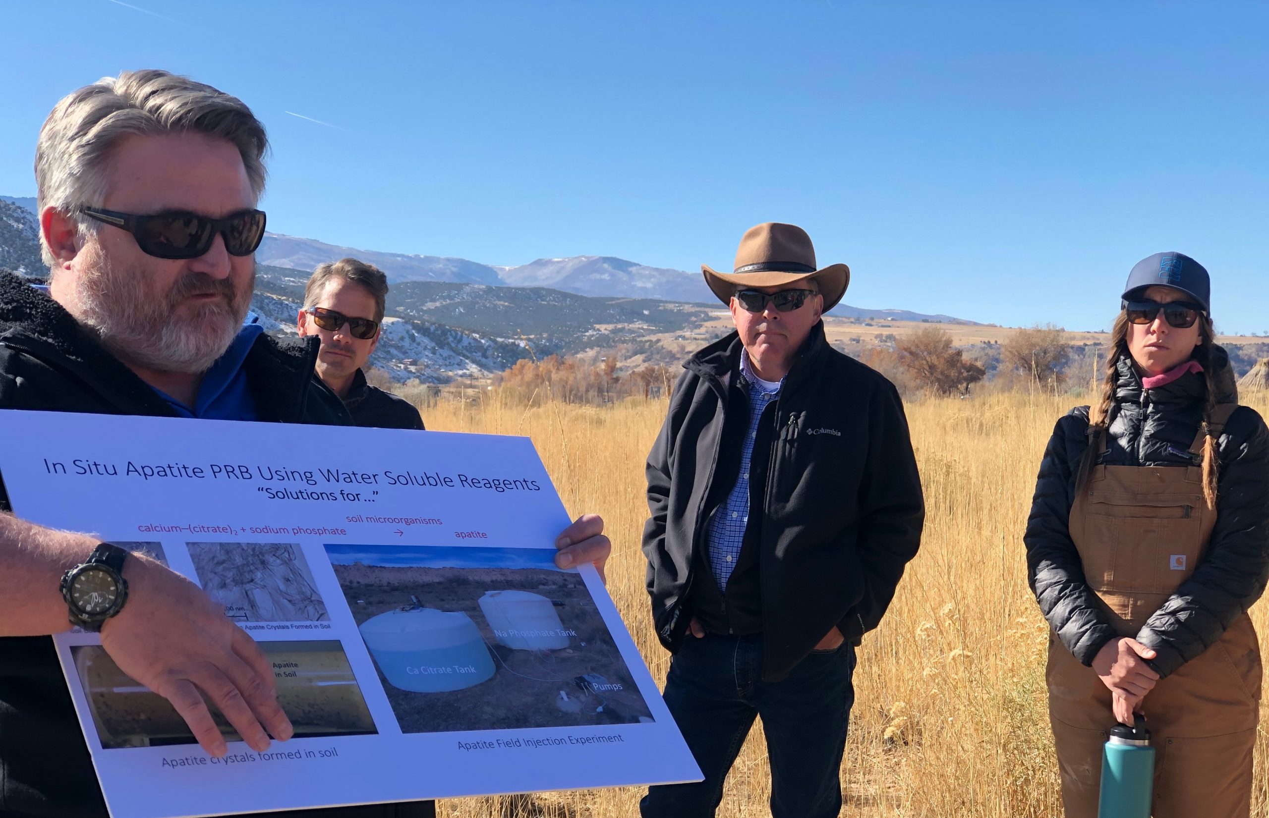 Mark Rigali, a Sandia National Laboratories geochemist, left front, presents the apatite remediation technology to legacy management stakeholders during a demonstration at the former uranium mill near Rifle, Colorado in 2019. Ken Williams, the Lawrence Berkeley environmental remediation program lead, stands behind him and observes.