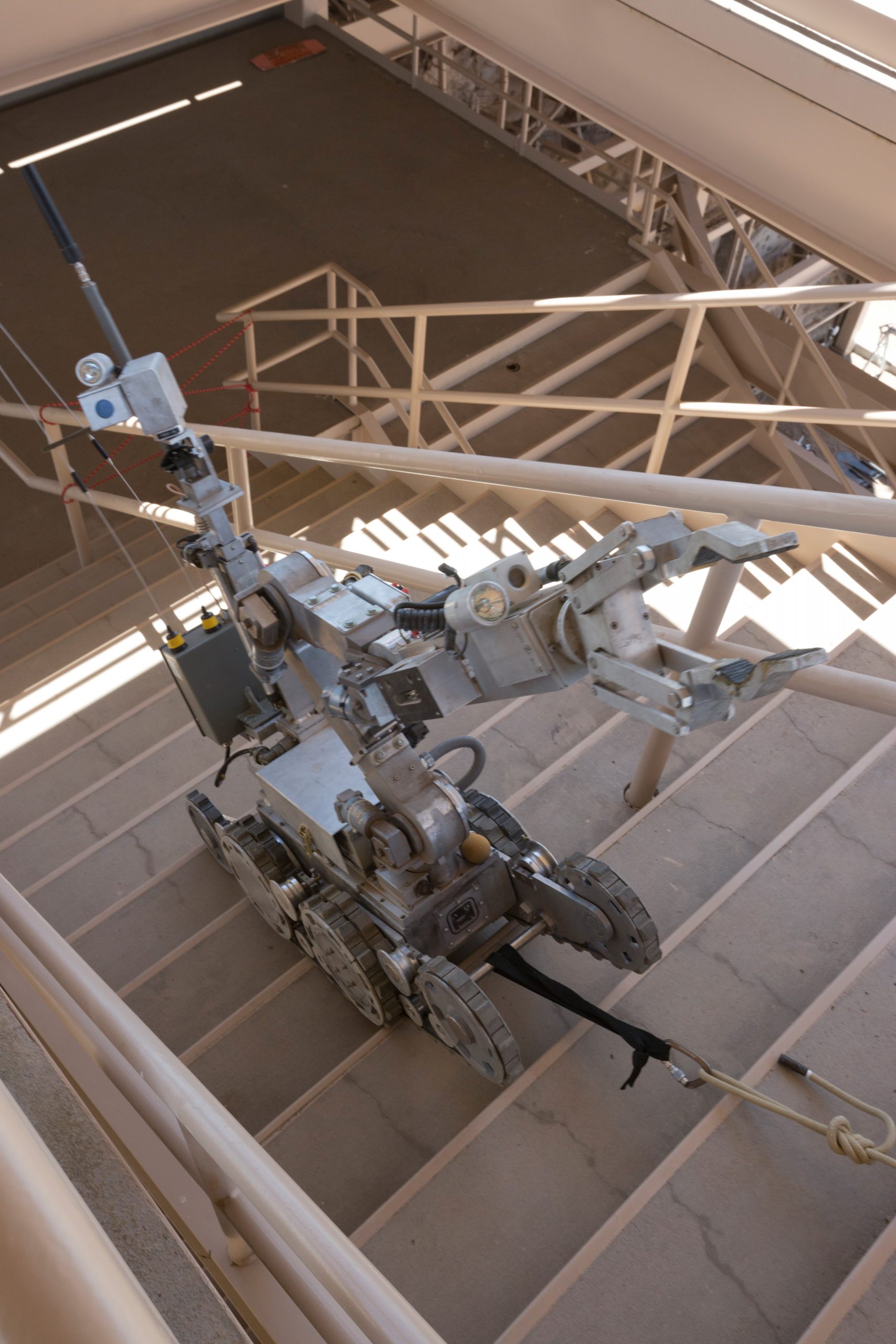 A hazardous duty robot climbs the second of three flights of stairs during the 2017 Robot Rodeo at Sandia National Laboratories. The safety line catches the robot if it falls, ensuring it doesn’t get damaged.