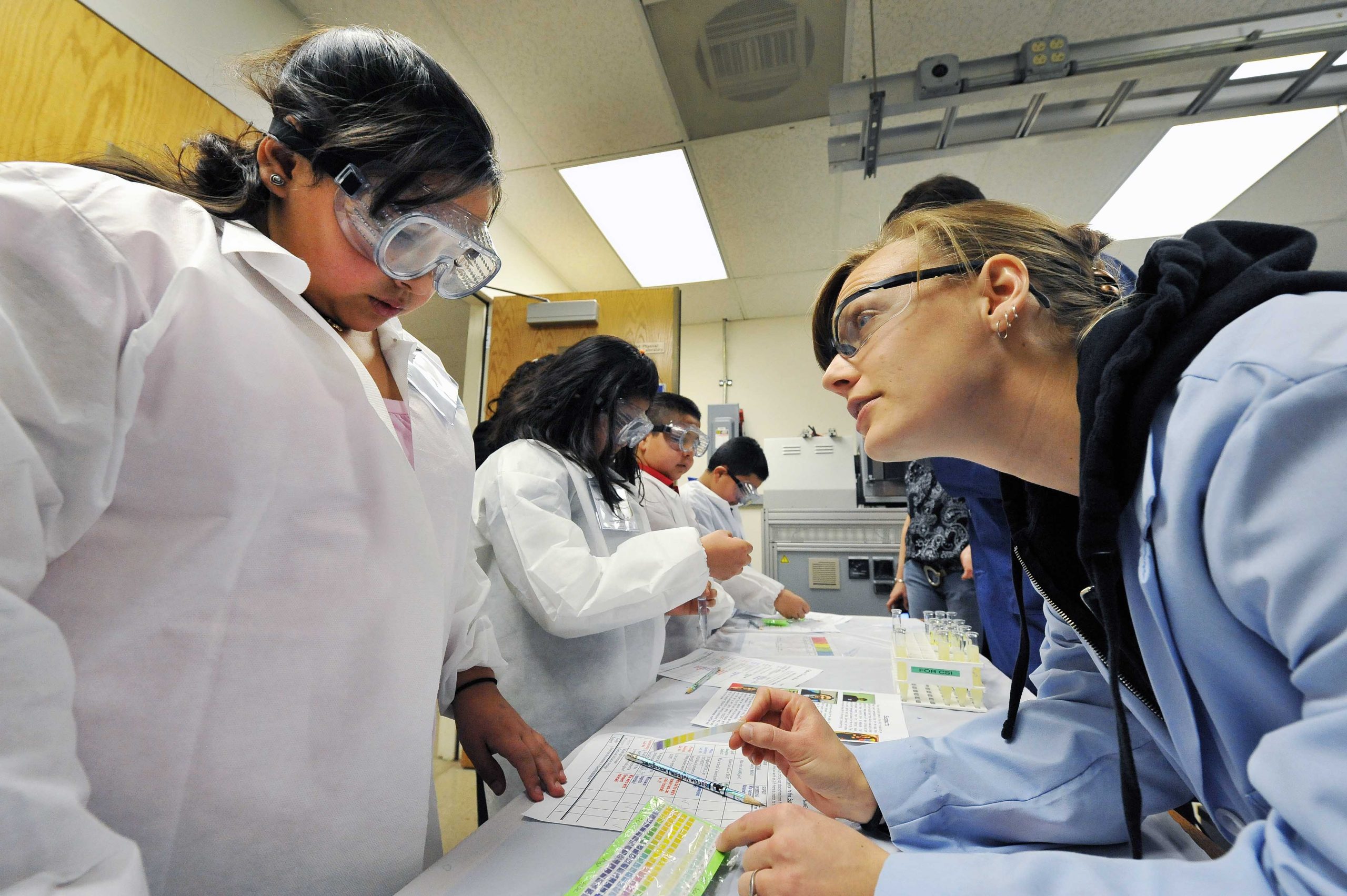 A scientist from Sandia National Laboratories works with students at a prior community outreach event. STEM Mentoring Café will offer speed mentoring sessions to engage girls in STEM careers.
