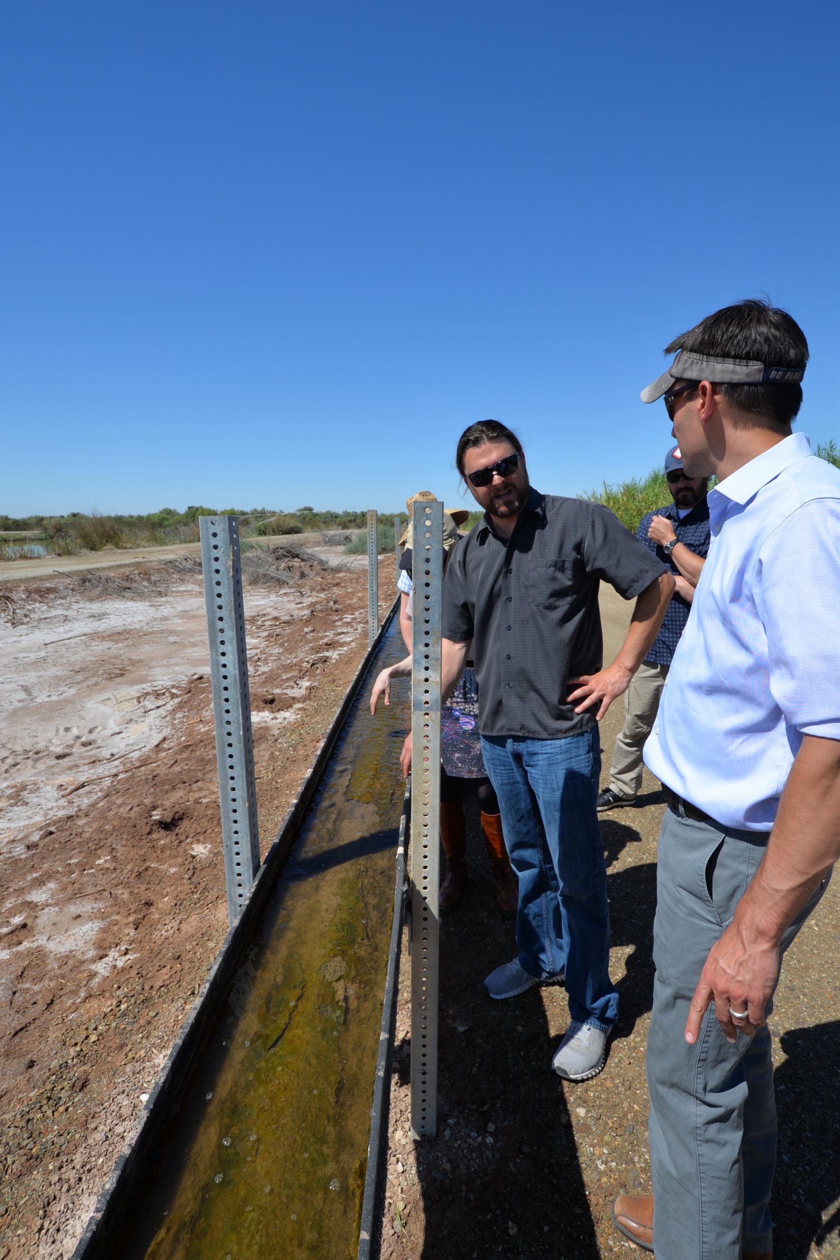 Sandia National Laboratories biochemist Ryan Davis, left, takes guests on a tour of the SABRE Project system.