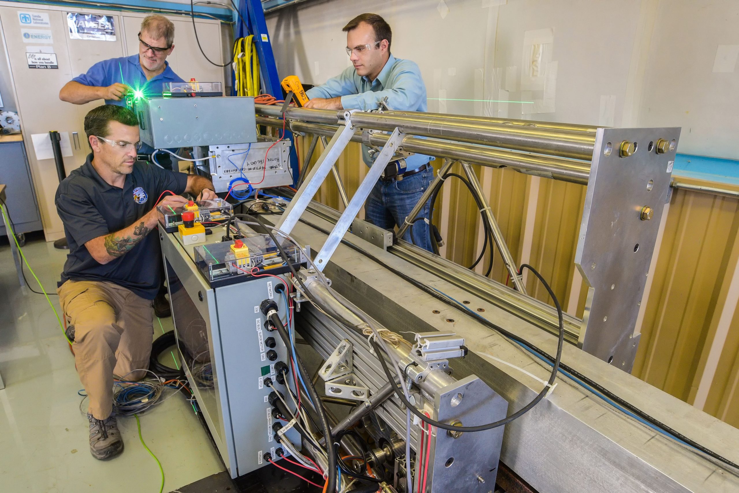 Sandia National Laboratories robotics researchers Clint Hobart, left, Kevin Dullea, center, and Steven Spencer prepare the wave energy converter’s actuator for testing.