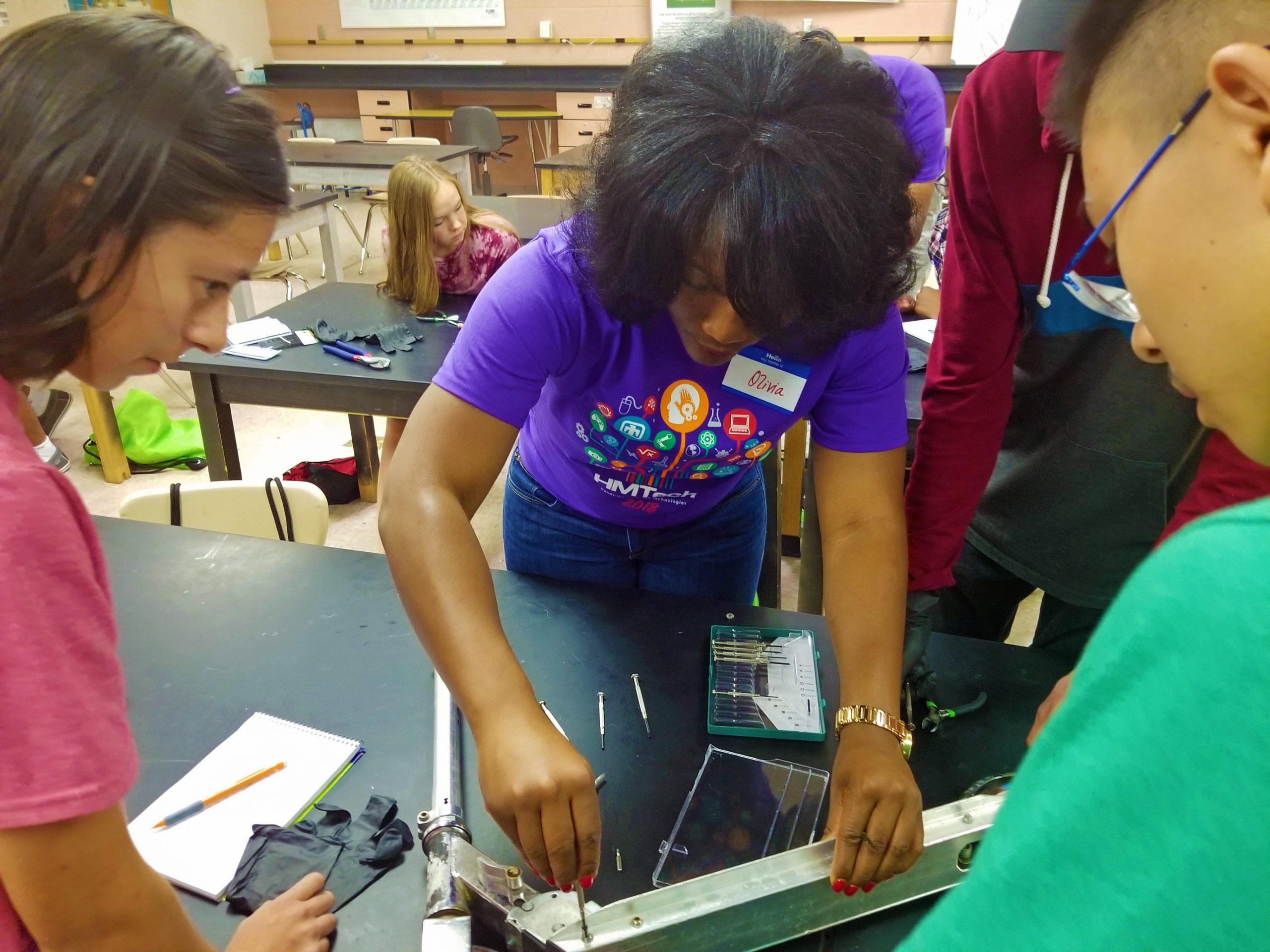Sandia National Laboratories materials scientist Olivia Underwood helps students disassemble a scooter during her materials science class. This is the first year she has served as a HMTech instructor.