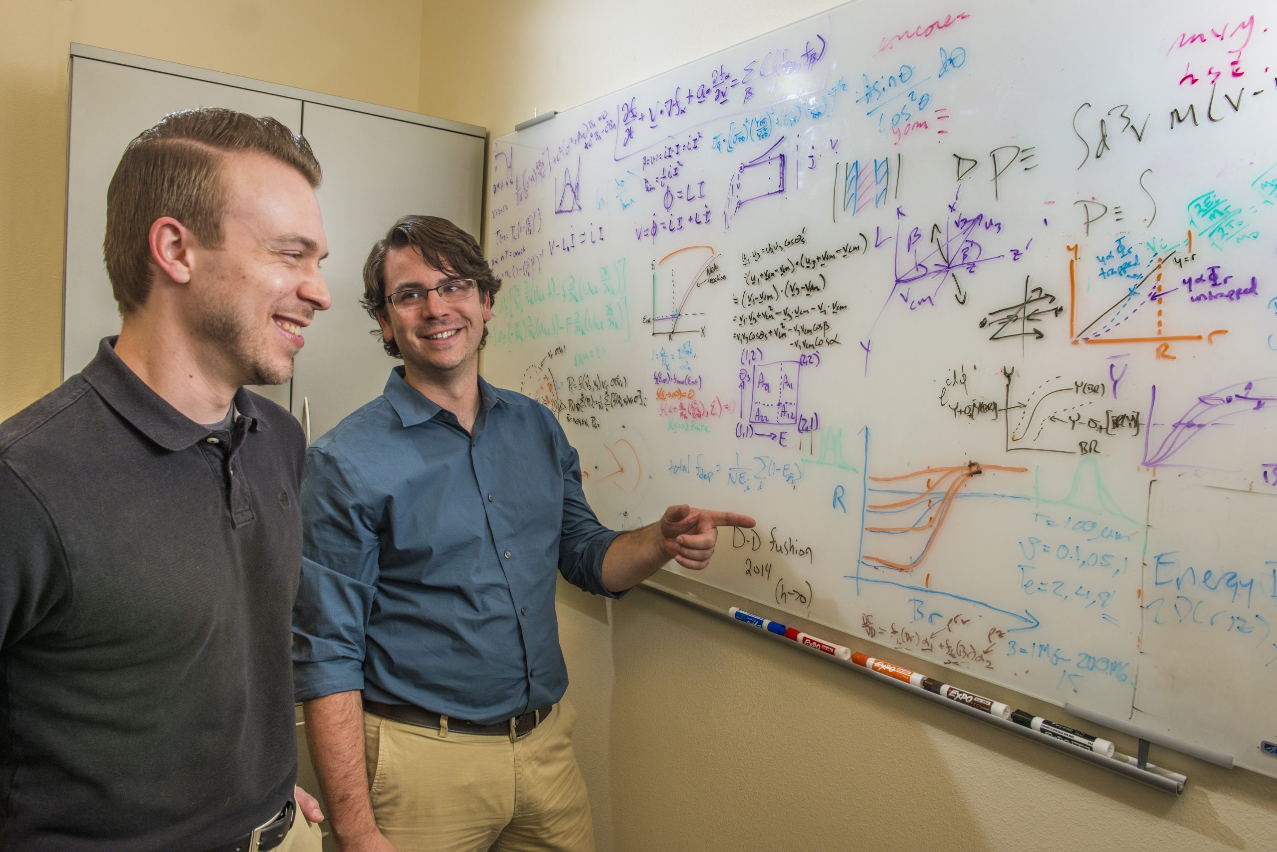 Sandia National Laboratories researchers Paul Schmit, left, and Patrick Knapp discuss equations and graphs that describe aspects of Sandia's Z machine.