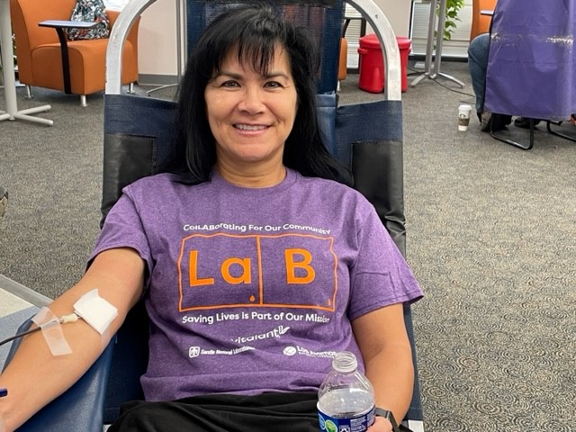 Sandia employee Miquela Beggs proudly wears a t-shirt given to blood donors at the 2023 blood donation competition between Sandia National Laboratories and Los Alamos National Laboratory.