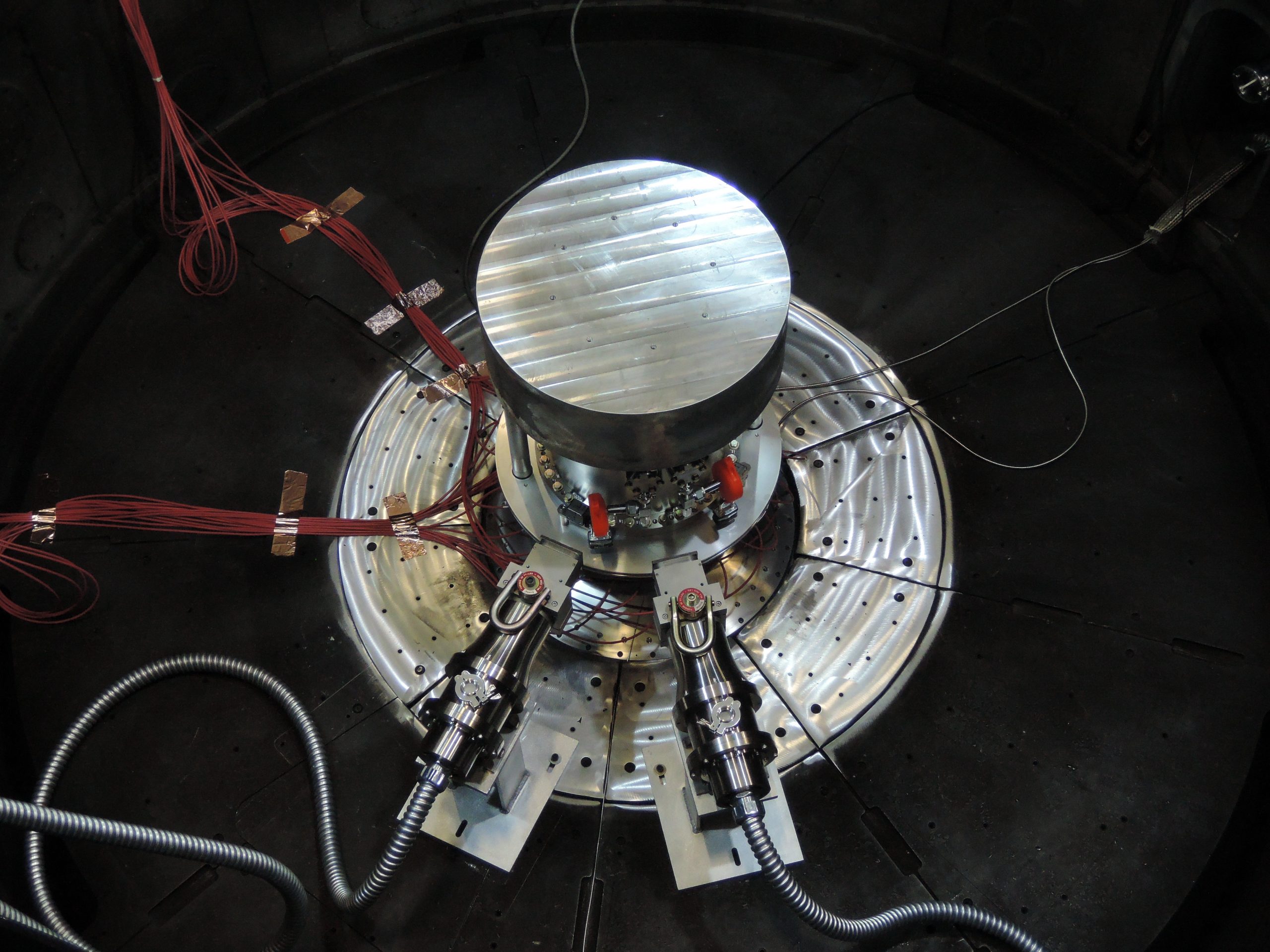 Two fast neutron radiation-effects cassettes aim toward the center of the containment system for tritium within the Z vacuum chamber at Sandia National Laboratories. The setup’s gas transfer system is housed within the containment system.