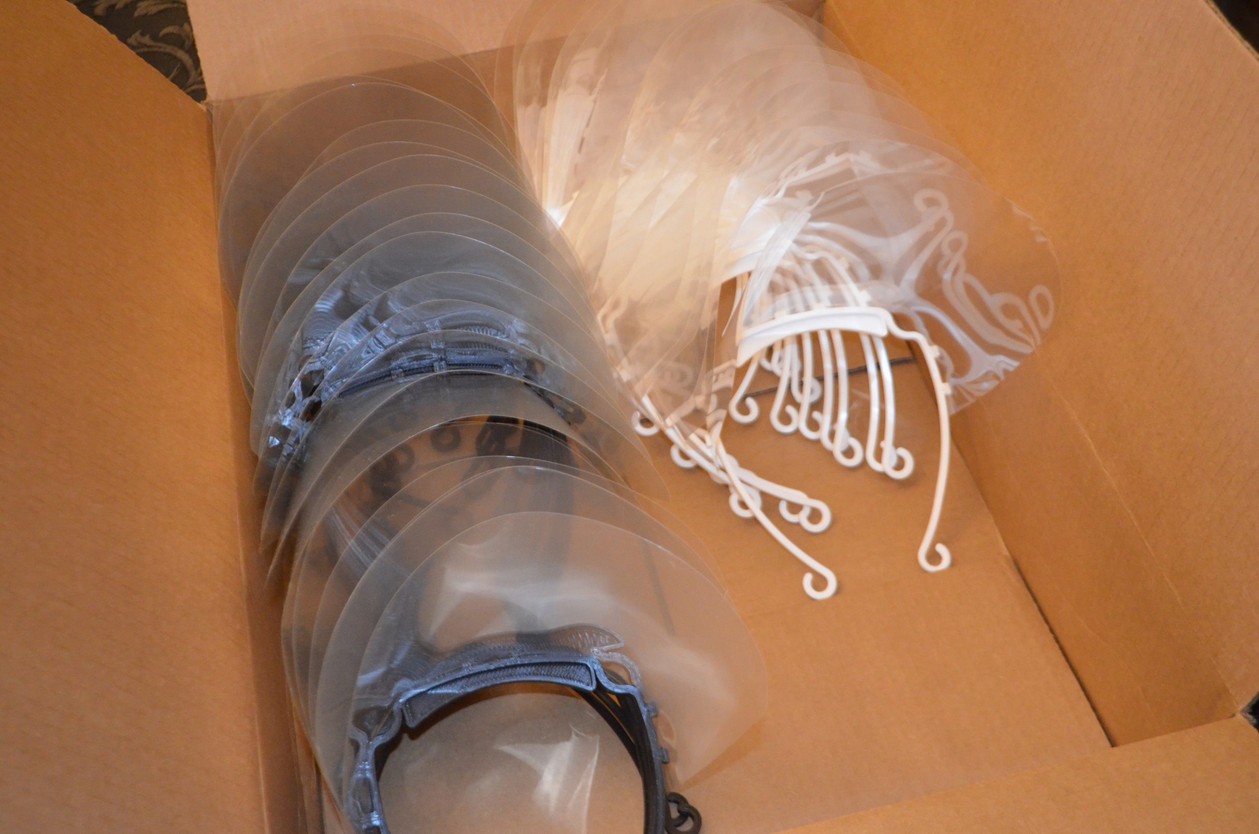 The teens 3D print bands that fit around the forehead, then attach them to plastic transparency sheets. After the face shields are assembled and sanitized, they are boxed up and donated at no cost to medical professionals.