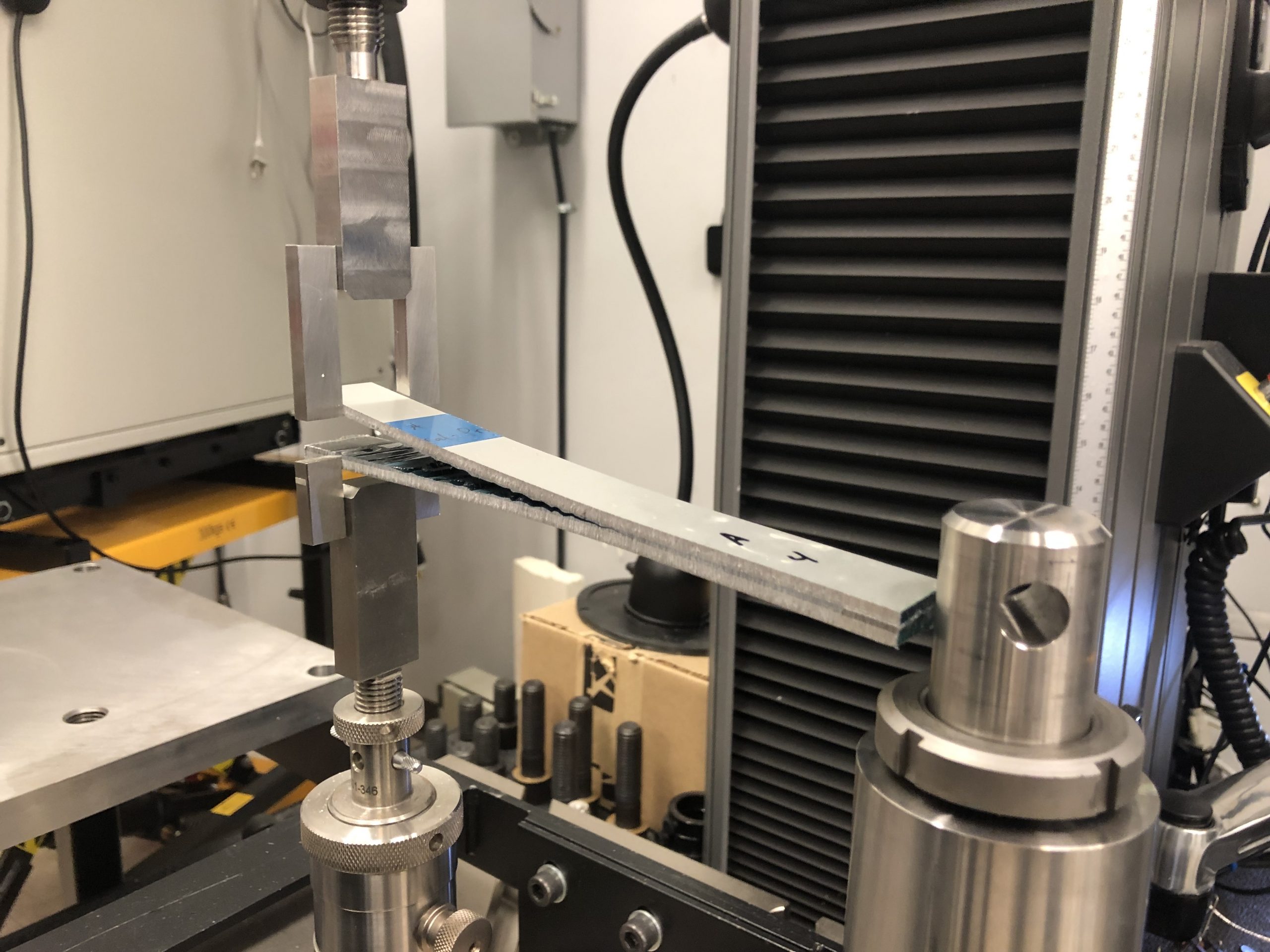 Sandia National Laboratories researchers in the Mechanics of Materials department utilize the new fracture testing hangers for traditional interlaminar fracture testing of cocured composites, advanced cobonded hybrid laminates, as well as metal-to-metal secondary bonded configurations as shown here.
