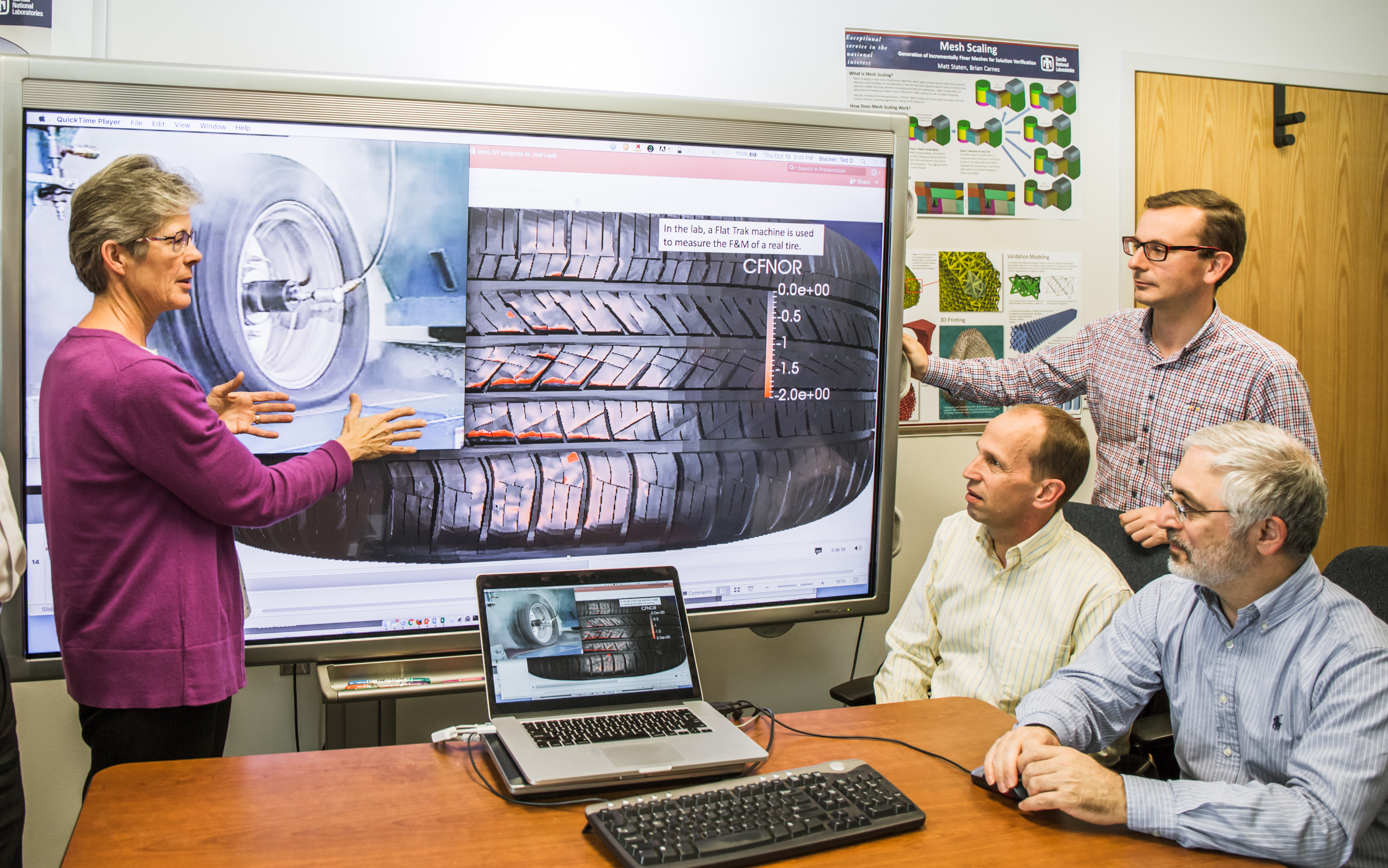 Sandia National Laboratories computer scientists Vicki Porter, left, and Byron Hanks, seated second from left, and engineers from Goodyear Tire & Rubber Co. study images of tire technology during a pre-COVID-19 work session at Sandia.