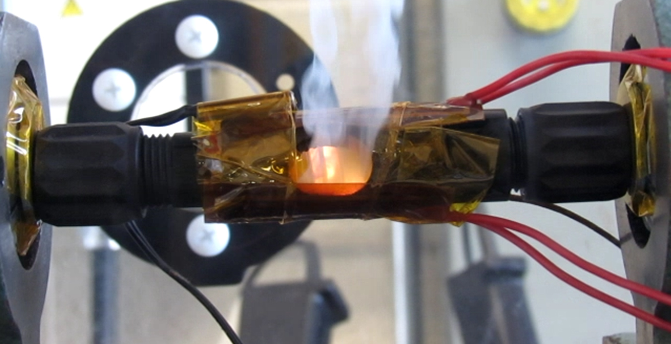 If there were a spark, a special polymer, developed by Sandia National Laboratories, within the in-line connectors would melt and a spring would extend inside the connector to facilitate a larger spark gap and stop the flames, as shown in this photo.