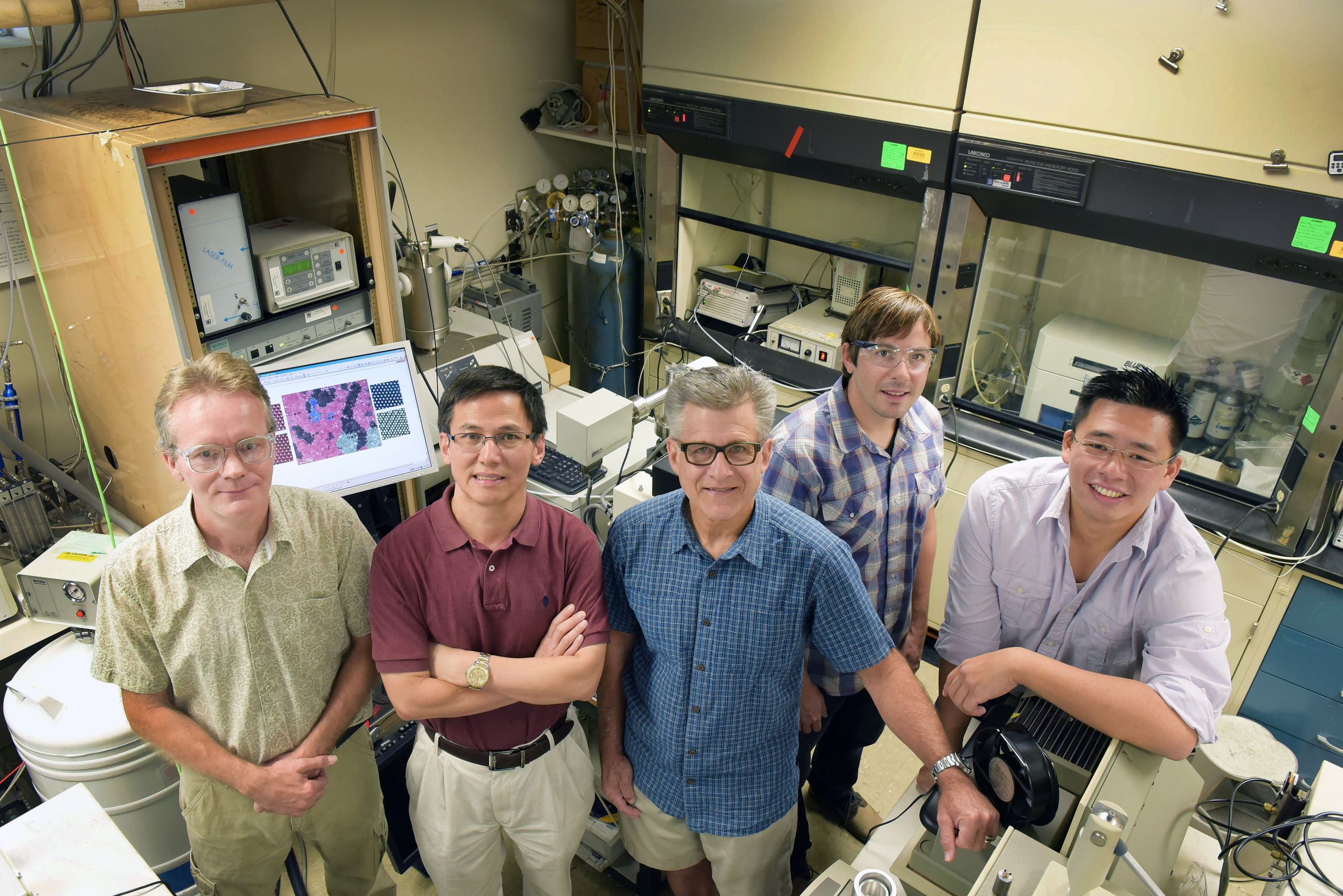 Sandia National Laboratories researchers, from right, Stan Chou, Bryan Kaehr, Jeff Brinker, Ping Lu and Eric Coker, gather in a lab where work on the catalyst molybdenum disulfide was achieved.