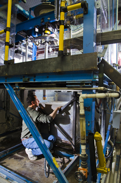 Elton Wright examines a prototype drill bit used for an experiment in Sandia’s Hard-Rock Drilling Facility.