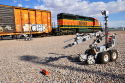 The annual Robot Rodeo at Sandia National Laboratories gives participants the opportunity to practice using robots to resolve realistic scenarios. Robots, guided remotely by handlers, had to search in and around four rail cars for devices in this 2011 simulation.