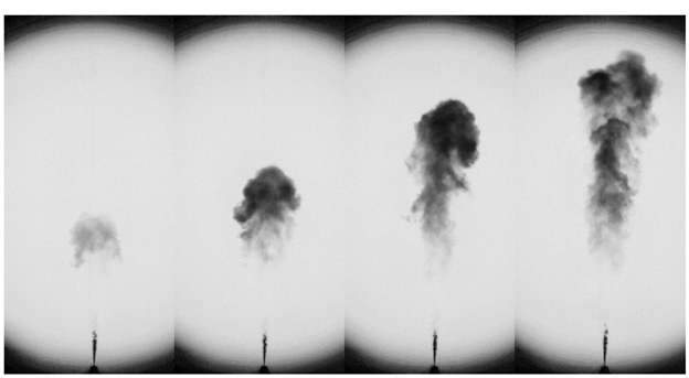 Time sequence of images in a Sandia National Laboratories project that shows the extinction of light caused by a soot cloud formed during the injection of a diesel spray. The liquid fuel spray is seen at the bottom of the images and appears dark because the light passing through the combustion vessel is scattered by the liquid droplets. The soot cloud downstream appears dark mainly due to absorption of light by the soot particles.