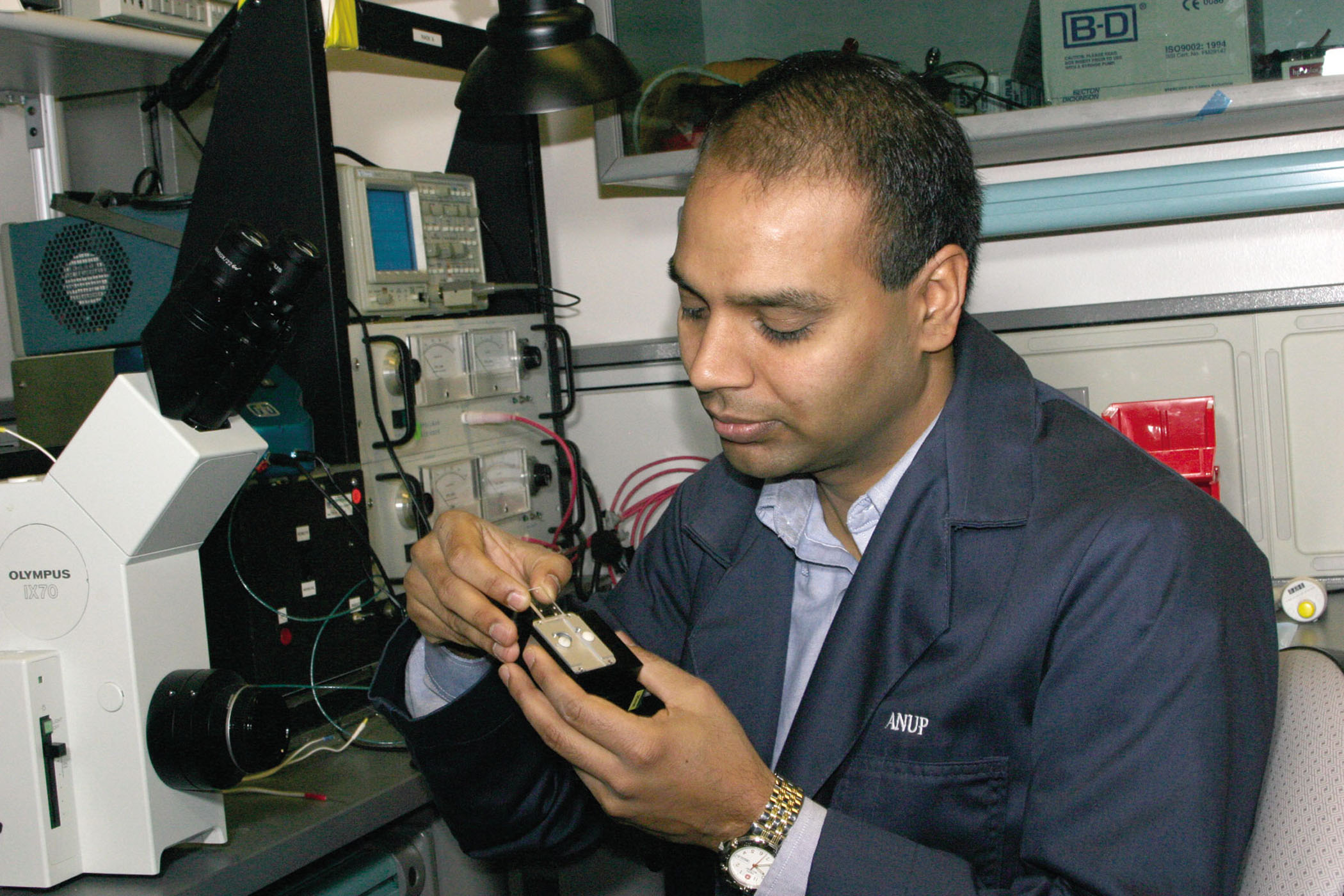 Researcher Anup Singh inserts an immunoassay chip into the microfluidic module of the hand-held device.