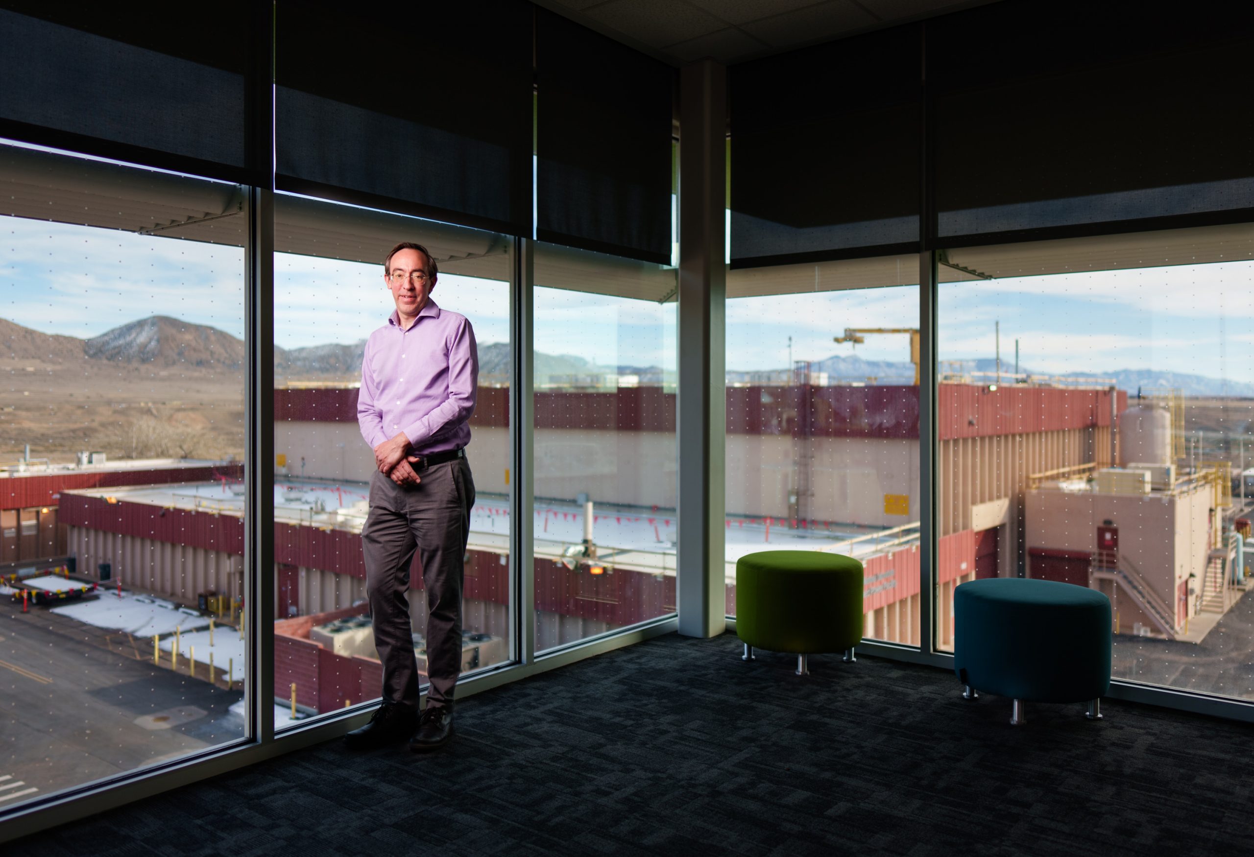 Sandia National Laboratories physicist Nathan Moore stands with the Z machine facility framed in the background, the source of his asteroid data.