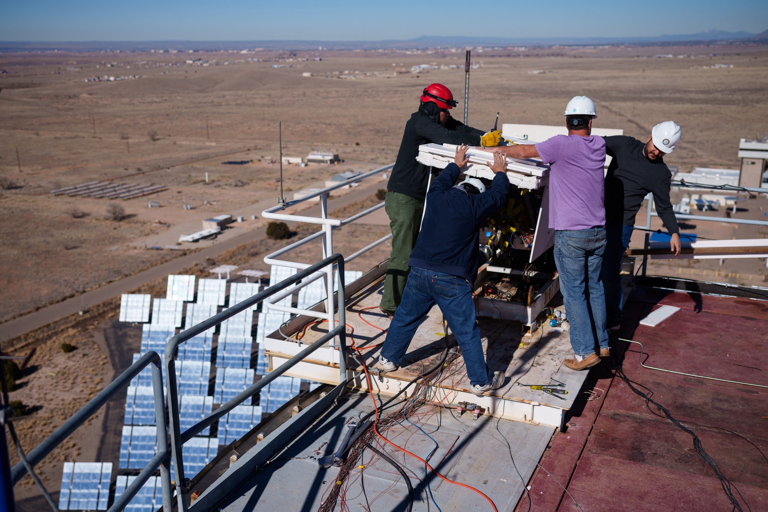 Sandia National Laboratories engineer Aaron Overacker, left, and NASA engineers Owen Nishioka, Keith Peterson and Milad Mahzari, cover the heat shield material after a December 2023 test at Sandia National Laboratories. This is so that the material can cool in an oxygen-deprived environment. 
