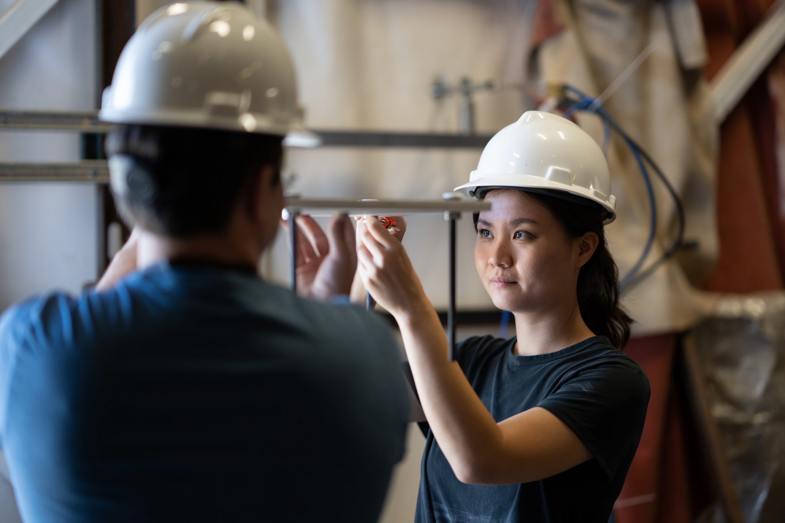 Jessica Harsono, right, a mechanical engineer at the Johns Hopkins Applied Physics Laboratory, sets up the test article for mounting to Sandia National Laboratories’ Solar Tower fixture during a September 2022 test.