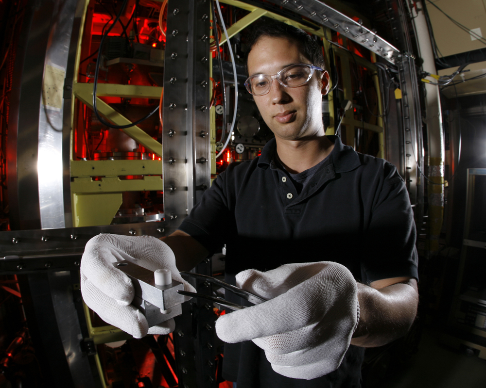 Sandia researcher Aaron Highley prepares a complex metal hydride sample for reaction kinetics analysis in the Simultaneous Thermogravimetric Modulated Beam Mass Spectrometer (STMBMS). This instrument, which was developed in the 1980s to assess the reaction kinetics that underlie the safety and aging behavior of high explosives and rocket propellants, is now being utilized to investigate the safety properties of automotive hydrogen storage materials.<br />
(Photo credit: Randy Wong)