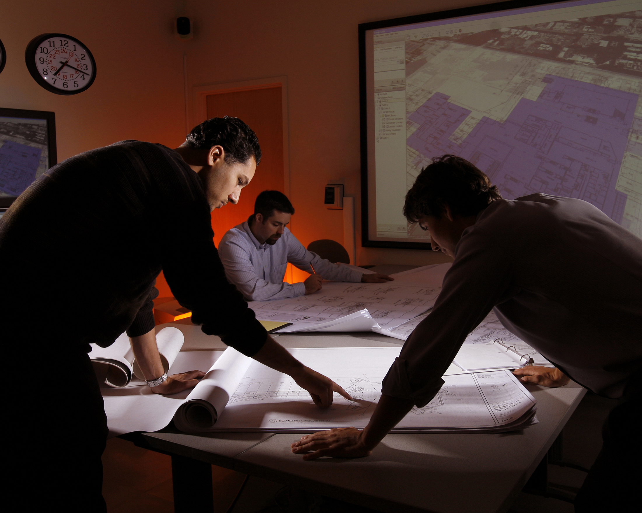 Sandia researchers Nerayo Teclemariam, Nate Gleason, and David Franco (left to right) review facility plans from a major U.S. airport. Such materials, combined with decades of research, help BIRC team members make accurate predictions for facility owners that can help secure and protect their buildings. (Photo by Randy Wong)<br />
Download 300dpi 11MB JPEG image (Media are welcome to download/publish this image with related news stories.)