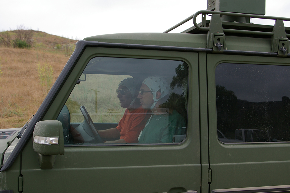 Sandia researcher Chris Forsythe, foreground, and companion drive a modified military vehicle as part of an experiment with smart cars.
