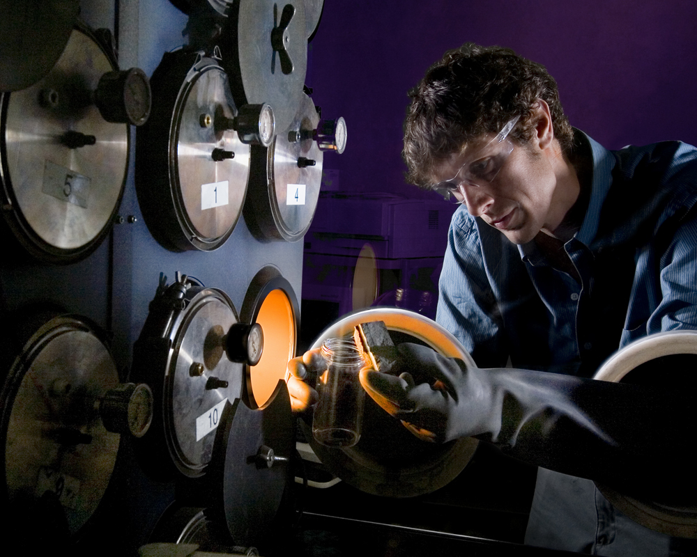 Sandia's Daniel Dedrick handles a complex metal hydride within an inert production and storage environment. Complex metal hydrides, along with many hydrogen storage materials, react readily when exposed to air and moisture. A Sandia-led project was initiated to quantify the reactivity of these materials to enable safe production, handling, storage, and utilization within the context of full-scale automotive applications. (Photo credit: Randy Wong)