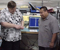 H2scan CEO Dennis Reid discusses hydrogen sensor chip with lead calibration technician Antonio Adan.