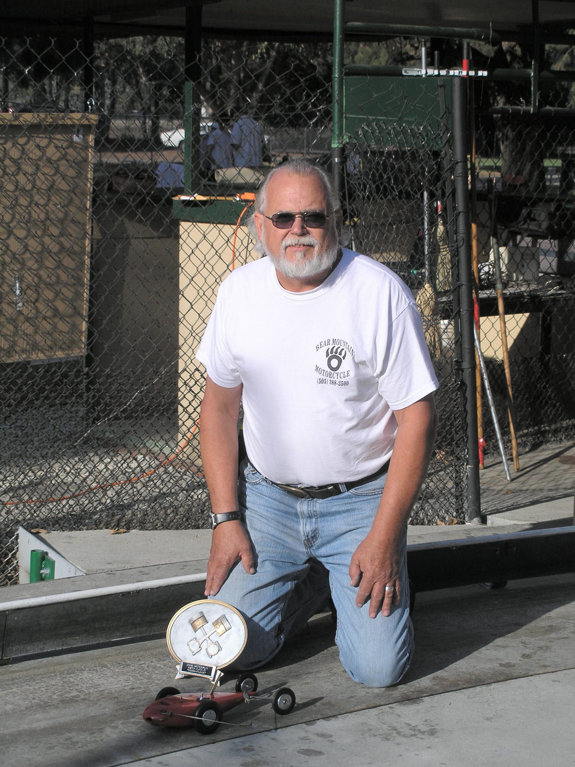 EXACTLY THE SAME - In these two pictures of Ed Baynes  -- after the Nationals competition at Anderson, Ind. in 1956, and after the same event held in the same place 50 years later -- the car is the same.  Ed of today, however, demonstrates better posture and cool sunglasses, if slightly stiffer knees.<br />
<br />
Download 300dpi 1.20MB JPEG( young Ed)<br />
Download 300dpi 2.5MB JPEG (Ed Sr.)<br />
(Media are welcome to download/publish this image with related news stories.) 