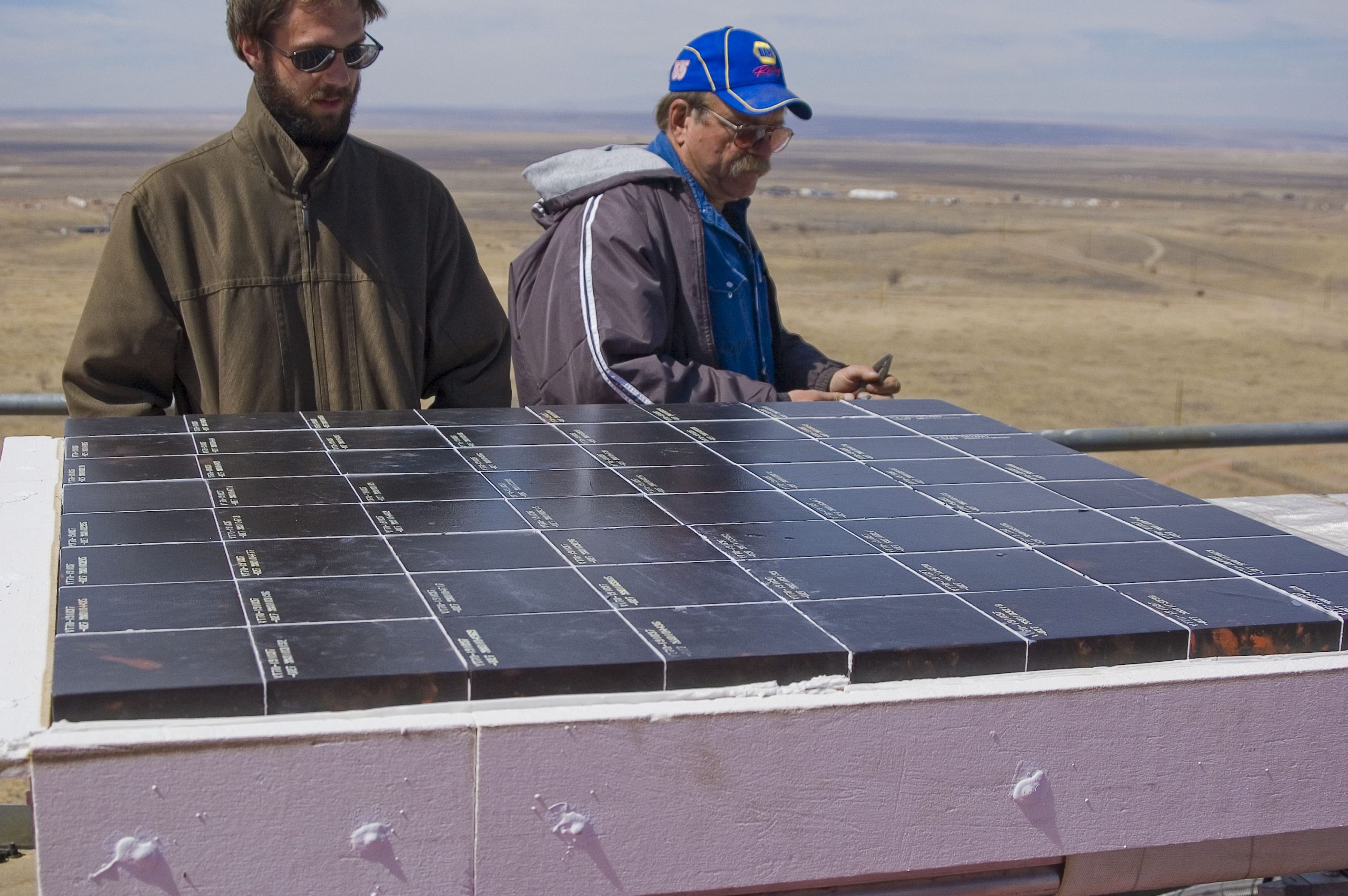 NASA’s Scott Splinter and Sandia’s JJ Kelton examine shuttle tiles used for the Tower experiment.<br />
Download 300dpi 2.1MB JPEG image (Media are welcome to download/publish this image with related news stories.)