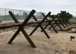 This type of surface-mounted vehicle barrier is currently deployed by Customs and Border Protection (CBP) in the southwest U.S. border region. The design style involves used railroad rails that are welded into the crossed 